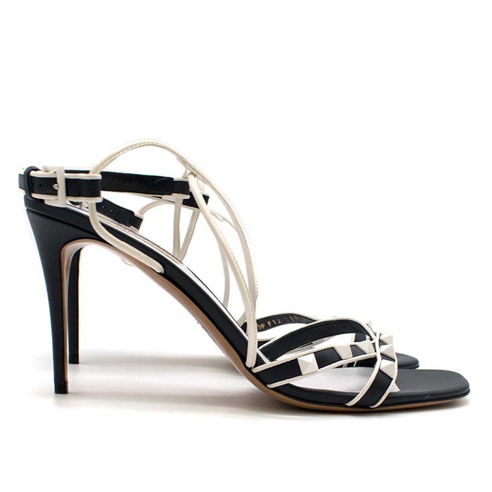 Valentino Garavani Navy & White Free Rockstud Sandals

Iconic Valentino Rockstud Sandal with heel,
Contrasting white piping,
Crossover straps in white Nappa,
Rubber-effect white studs,
Adjustable buckle closure,
Round open toe,
Leather insole and