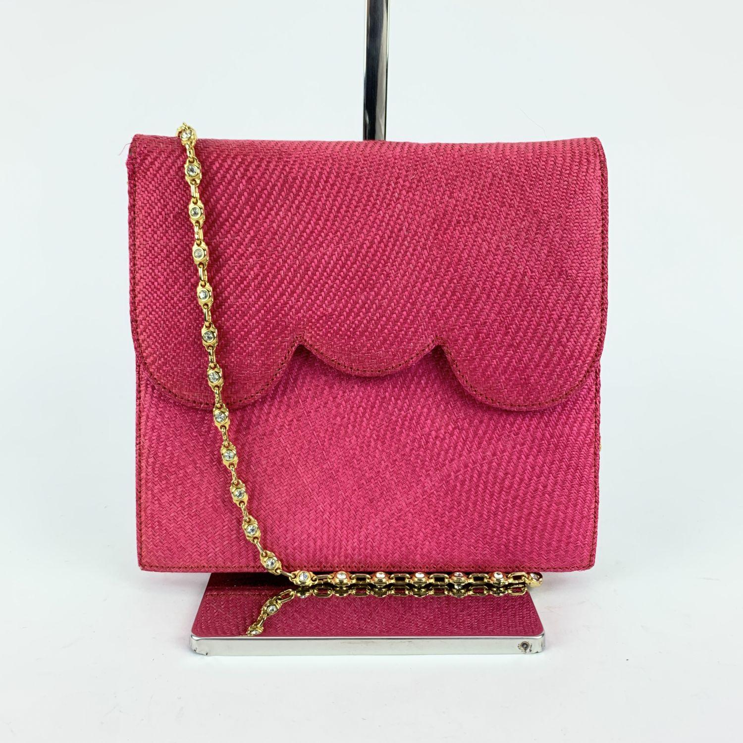 Evening bag signed NIGHT by VALENTINO GARAVANI. Woven raffia in hot pink color. Flap with magnetic button closure. Red leather on the reverse of the flap with embossed V- Valentino logo. Gros-grain fabric lining and 1 side zip pocket inside. Gold