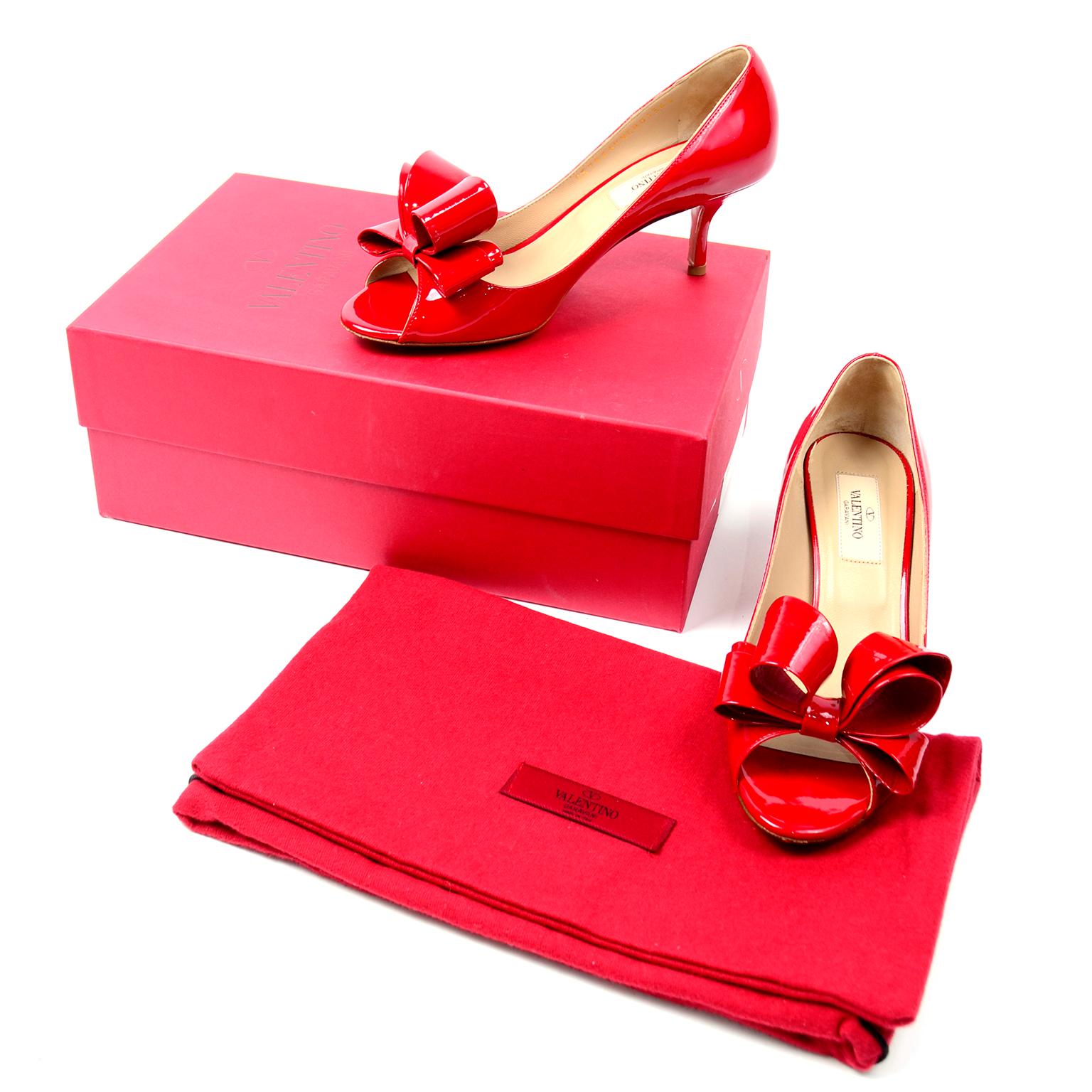 These fabulous iconic Valentino bow pumps are entirely crafted from a cherry red patent leather. These peep toe shoes have beautiful beige leather interior and sole. We love the structured bow that makes these shoes stand out. These shoes come with