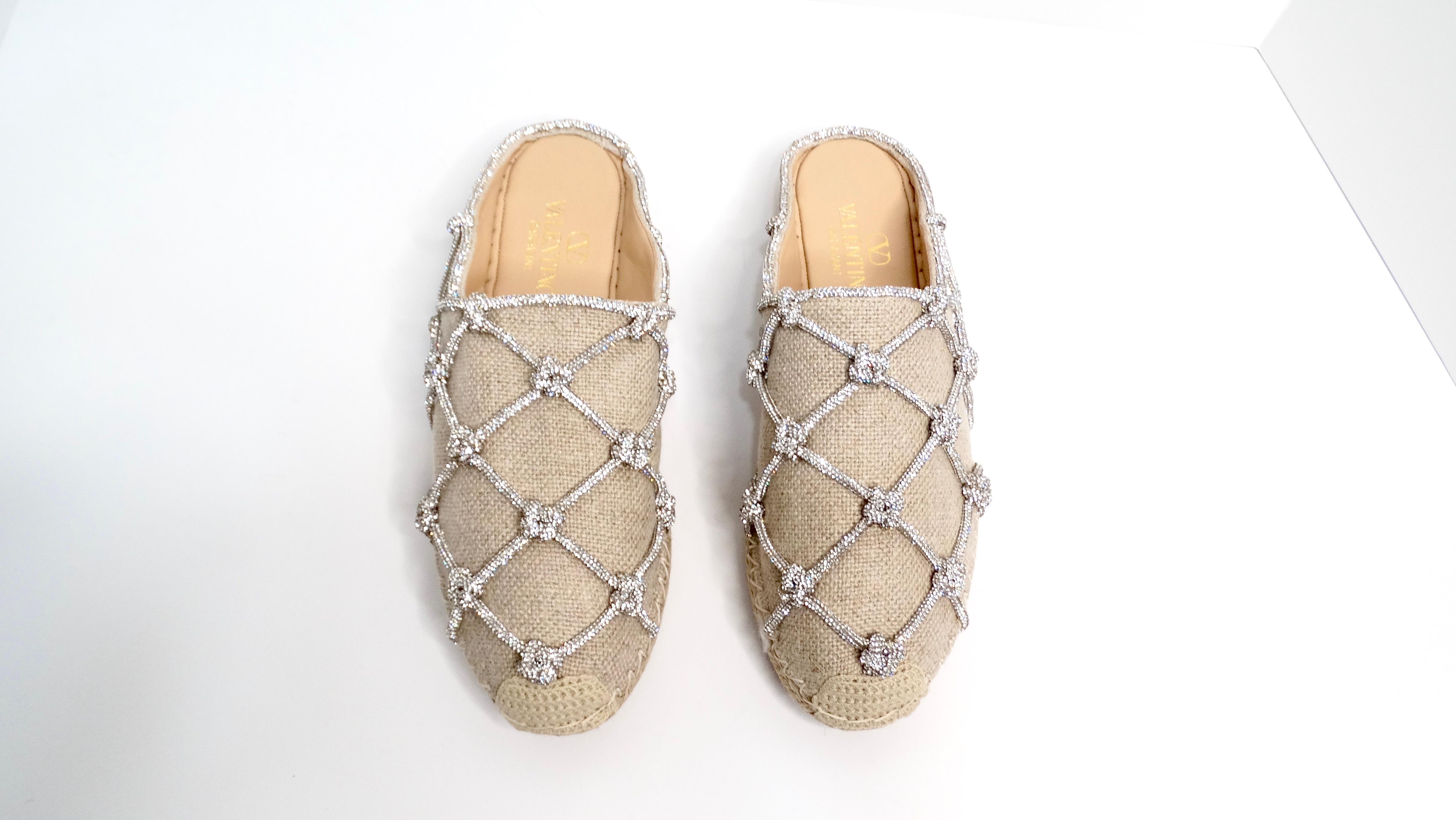 The Valentino Garavani Jute Resort Crystal Knot Caged Espadrille Mules epitomize luxury and effortless elegance. Constructed from a tan linen fabric, these mules feature a striking caged design adorned with delicate crystal knot detailing, adding a