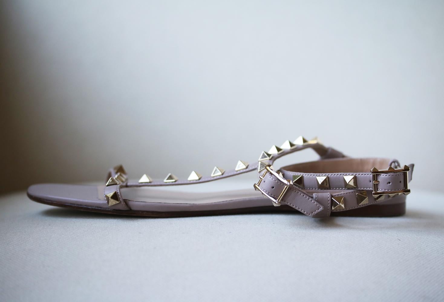Valentino's leather sandals have been crafted in Italy and hand-finished with pale-gold pyramid studs. Hand-embellished. Slight heel. Nude-pink leather. Signature pale-gold pyramid studs, open rounded-square toe. Buckle-fastening ankle straps. Does