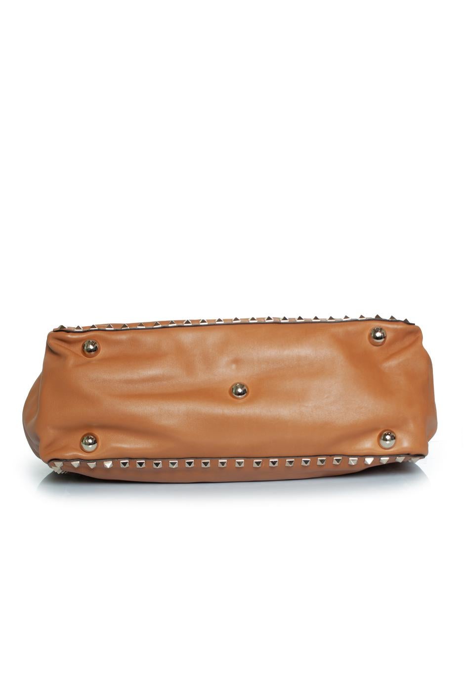 Valentino Garavani, Rockstud tote in camel. The leather has some dents from the studs further in very good condition. Interior is very clean. Comes with strap, tags and dustbag.

CONDITION: very good condition

MEASUREMENTS: height 26 cm, width 33