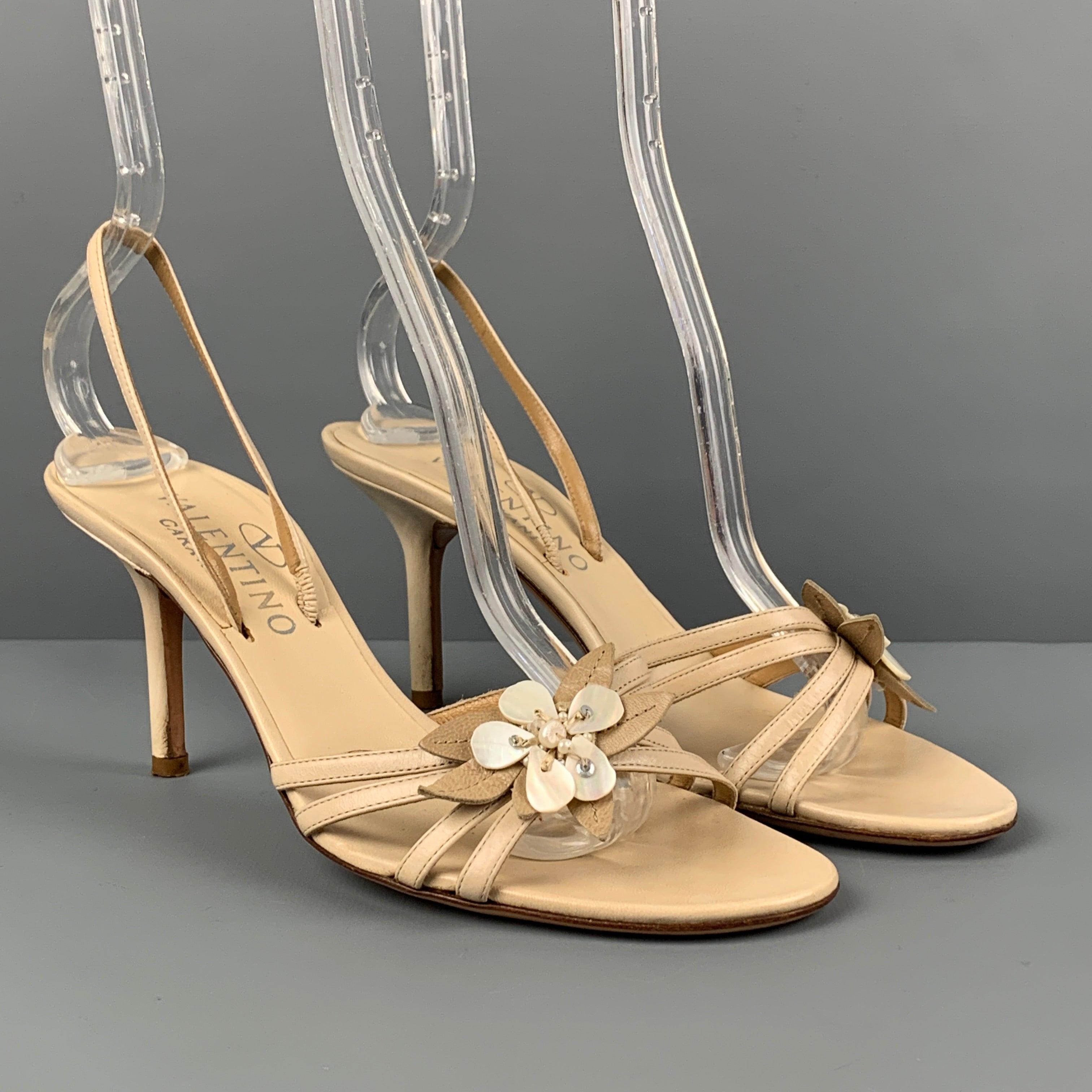 VALENTINO GARAVANI sandals comes in a beige leather featuring a slingback style, open toe, flower applique detail, and a stiletto heel. Made in Italy.Very Good
Pre-Owned Condition. 

Marked:   37 

Measurements: 
  Heel: 3 inches 
  
  
 
Reference: