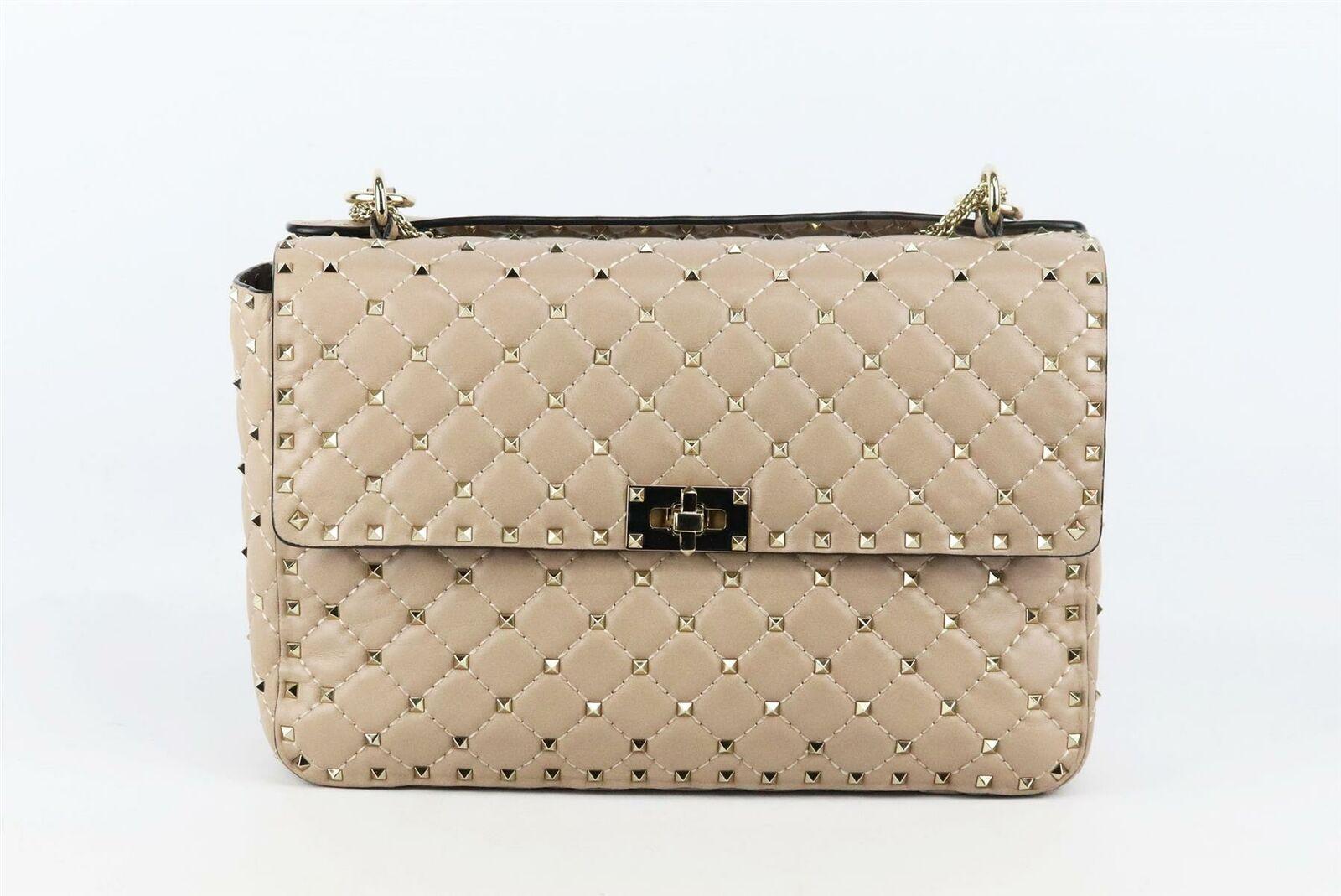 This Valentino Garavani 'Rockstud' bag is crafted in Italy from nude quilted leather, this large version is embellished with the signature pyramid studs and has a top handle or detachable shoulder strap for versatility.
Nude leather.
Twist lock
