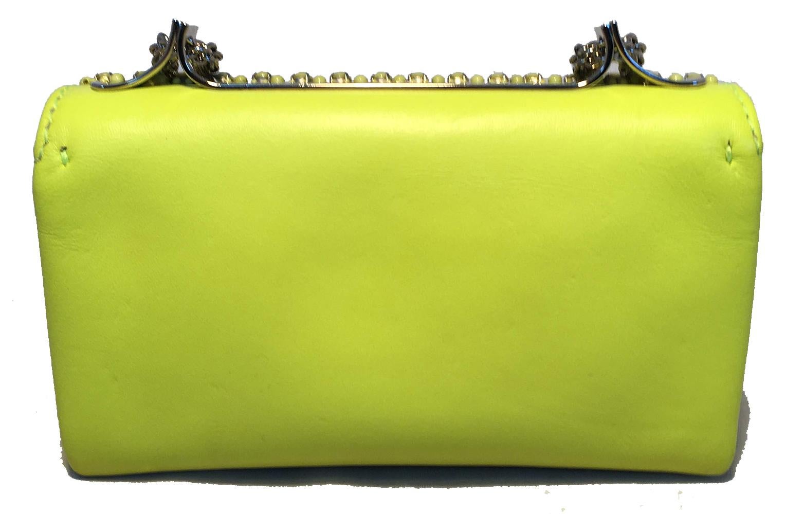 Valentino Garavani Va Va Voom Neon Studded Knuckle Clutch with Strap in excellent condition. Neon yellow/lime green leather and studded exterior trimmed with silver hardware and chain shoulder strap. Unique knuckle front handle to use as clutch.