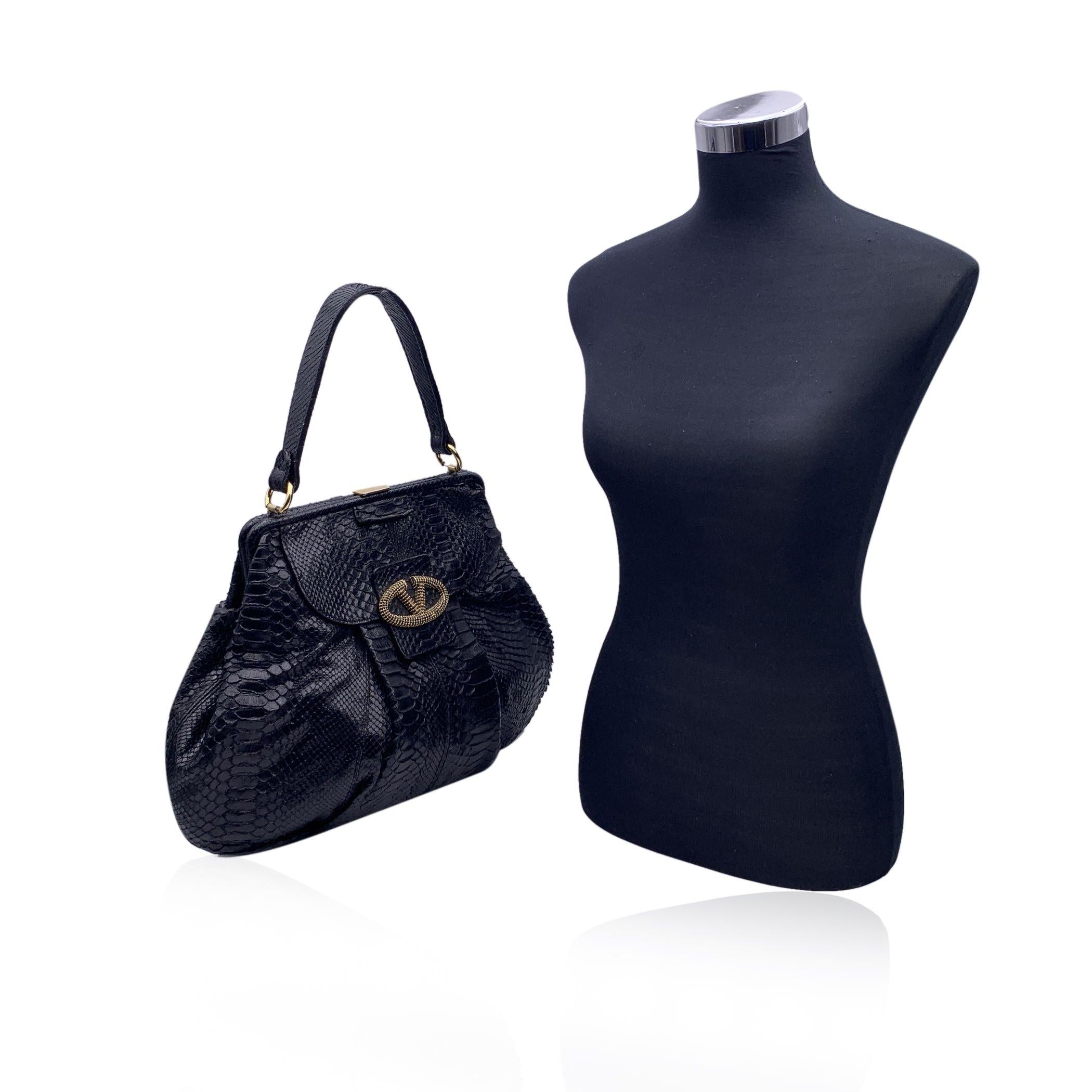 Vintage VALENTINO GARAVANI black leather large tote bag. The bag features gold V logo embellished with black crystals. Small front pocket inside. Framed top with upper clasp closure. Black fabric lining. 1 side zip pocke inside. 'Valentino Garavani'