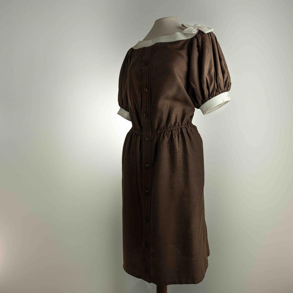 Valentino Garavani Viscose Mid-Length Dress in Brown.

Valentino Boutique brown dress with elastic waist and buttons on the front. 
At the base of the sleeves and all along the crew neck it has a band of white cotton, which has small patches given