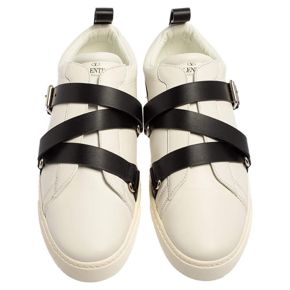 These sneakers from Valentino offer luxurious comfort. Made from white leather, the sneakers feature buckle strap detailing in black on the vamps and Rockstud accents on the back.

Includes: Original Dustbag, Original Box, Info Booklet, Extra