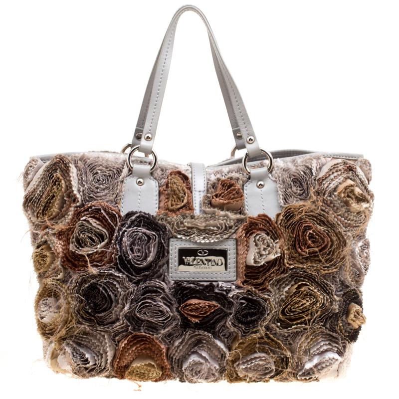 Set in a contemporary design and style, this flower tote from Valentino is absolutely mesmerizing. The lovely tote features beautiful fabric flower appliques all over it. It comes with dual leather handles, a spacious satin-lined interior to house