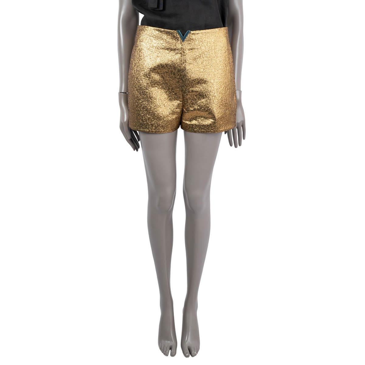 100% authentische Valentino Shorts mit hoher Taille aus Polyester mit Goldlamé (40%), Baumwolle (29%) und Metallic-Fasern (29%). Mit leicht goldfarbener VLOGO-Plakette am Bund (Schutzaufkleber noch vorhanden) und Knittertextur. Mit einem Haken und