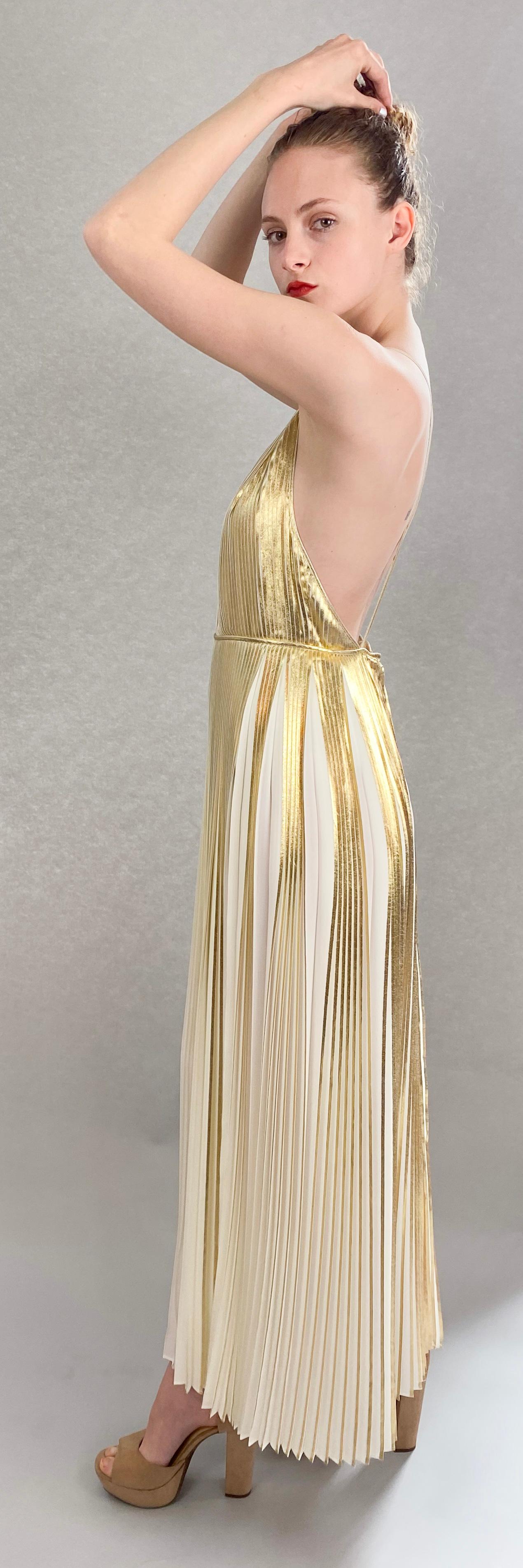 Discover a new level of luxury with our Valentino Gold Metallic Pleated Dress. Crafted from the finest lamé fabric, this dress features a sensual deep v neckline, accented by elegant under-bust piping. Elevate your style and make a statement with