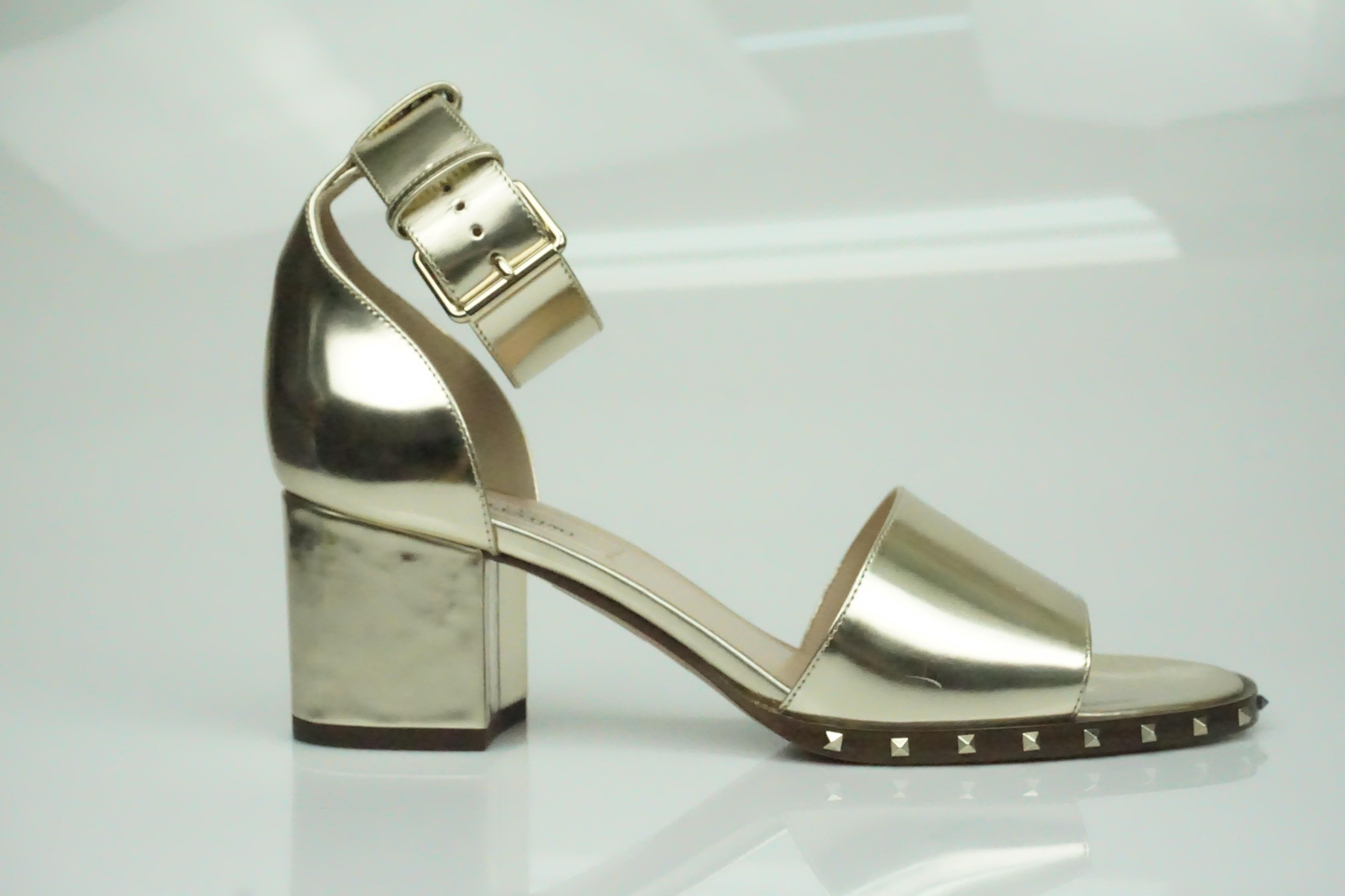 Valentino Gold Leather Soul Rockstud Ankle Strap Block Heel - 36.5  These beautiful heels are in excellent condition. They have barely been worn and look brand new. The shoe has studs surrounding the front foot. There is an ankle strap that is 1