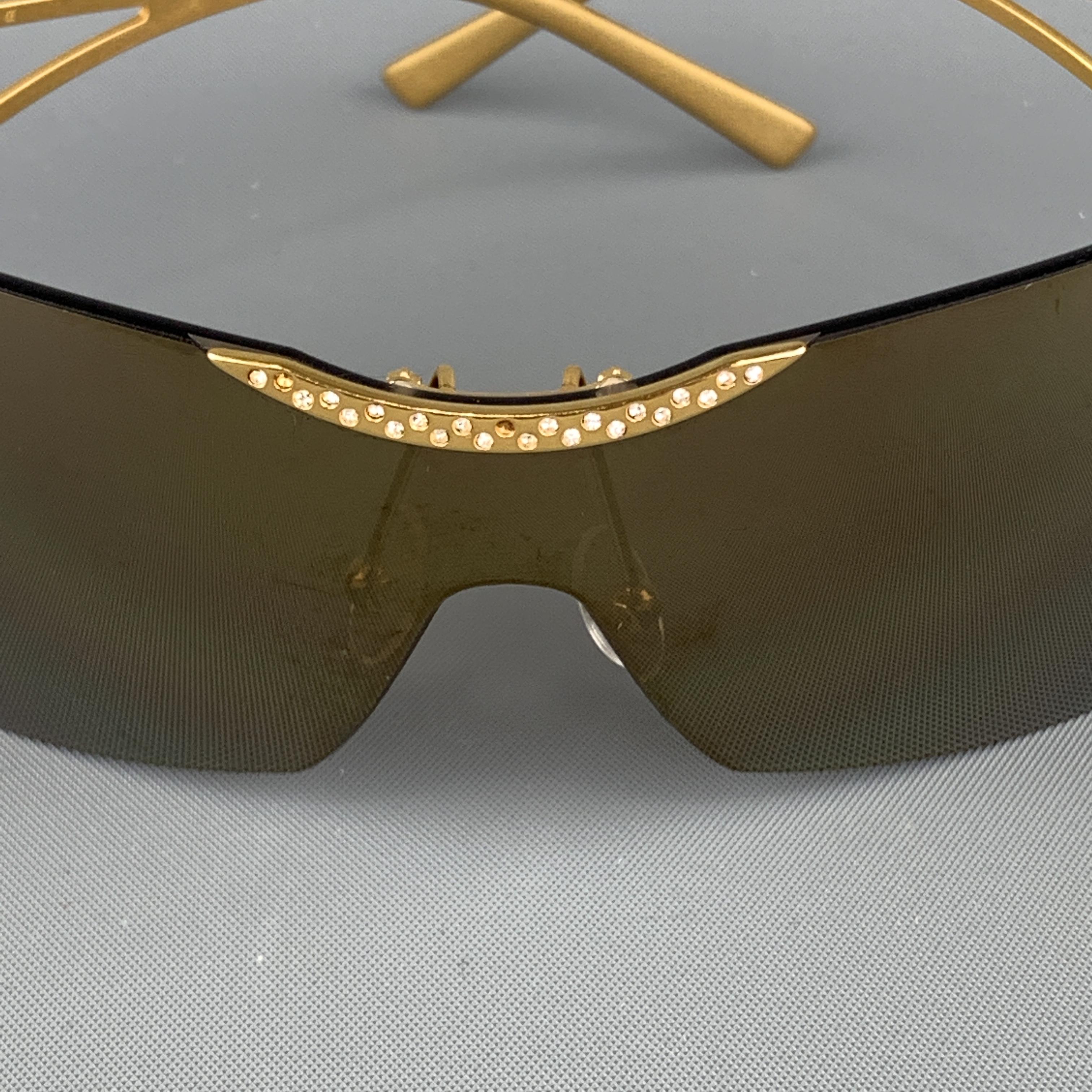 VALENTINO shield sunglasses come in gold tone metal with a metallic lens and rhinestone studded base. Wear throughout. Made in Italy.
 
Very Good Pre-Owned Condition.
Marked: 125 GOLD 0217 5RS 99 01
 
Width: 14 cm.
Height: 4 cm.