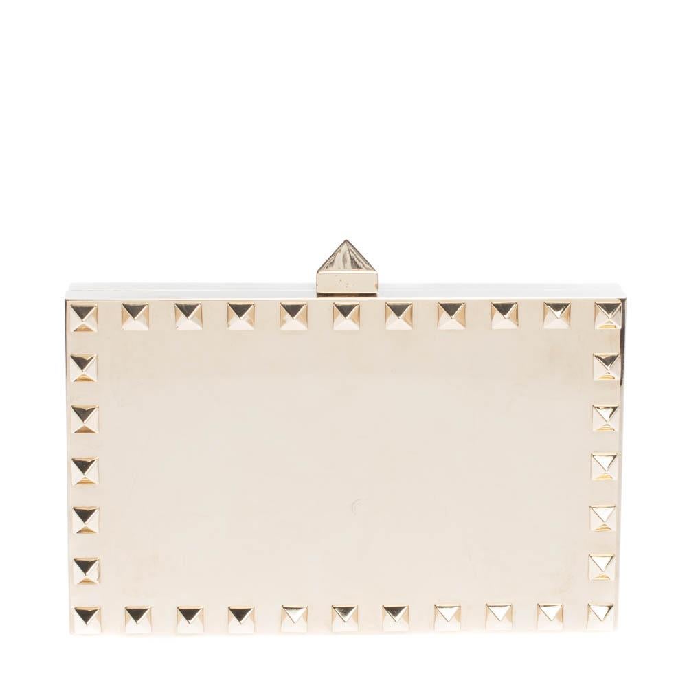 Creations so breathtaking and creative are hard to find! This awe-inspiring Minaudiere clutch from Valentino is just what you need to grab all the attention at those soirees and parties. Covered from the signature Rockstuds, it has a structured body