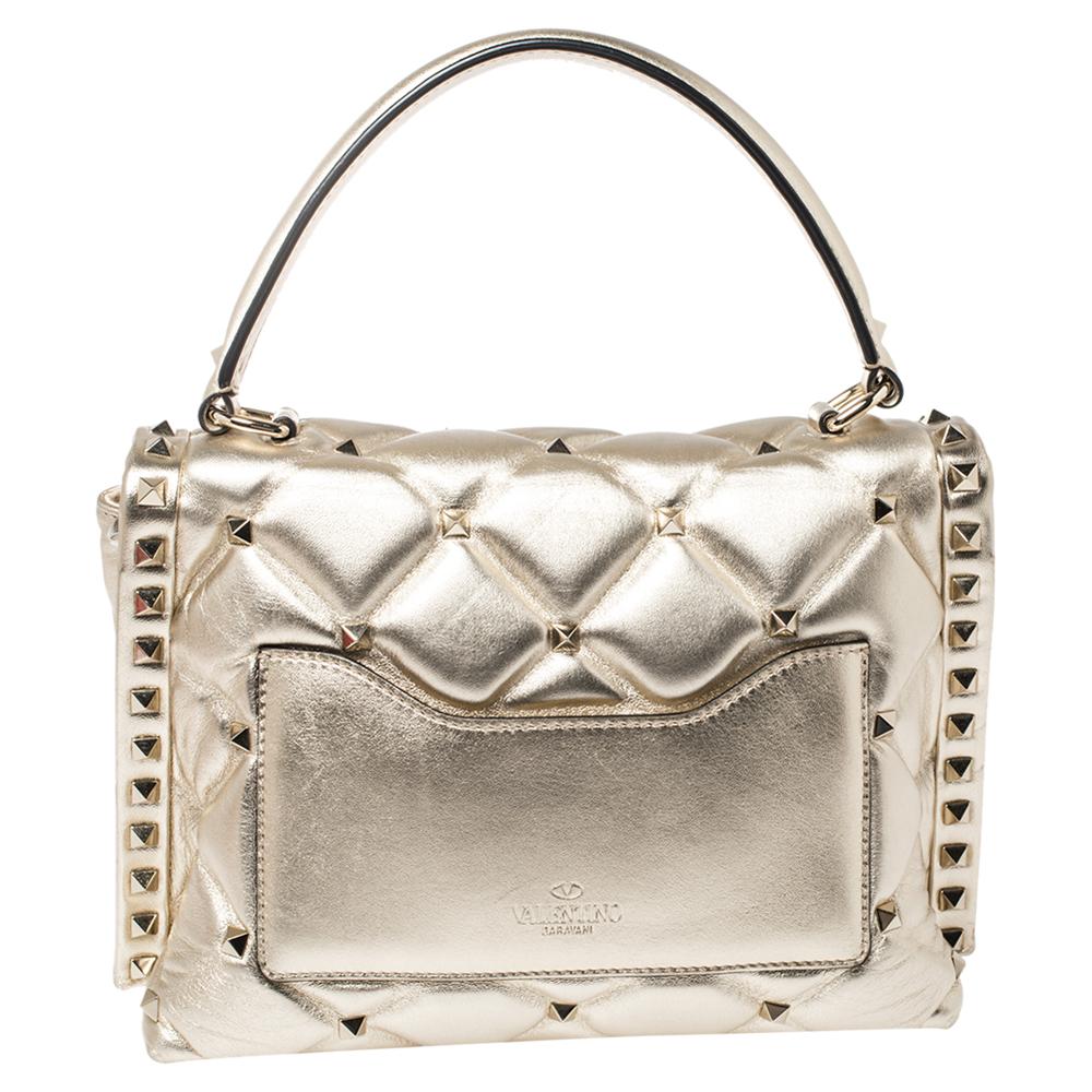 Valentino's Candystud is full of beauty, signature elements, and wondrous details. It is crafted from leather in a gold hue and punctuated with studs on the quilted surface. It is complete with a top handle and shoulder strap for you to parade the