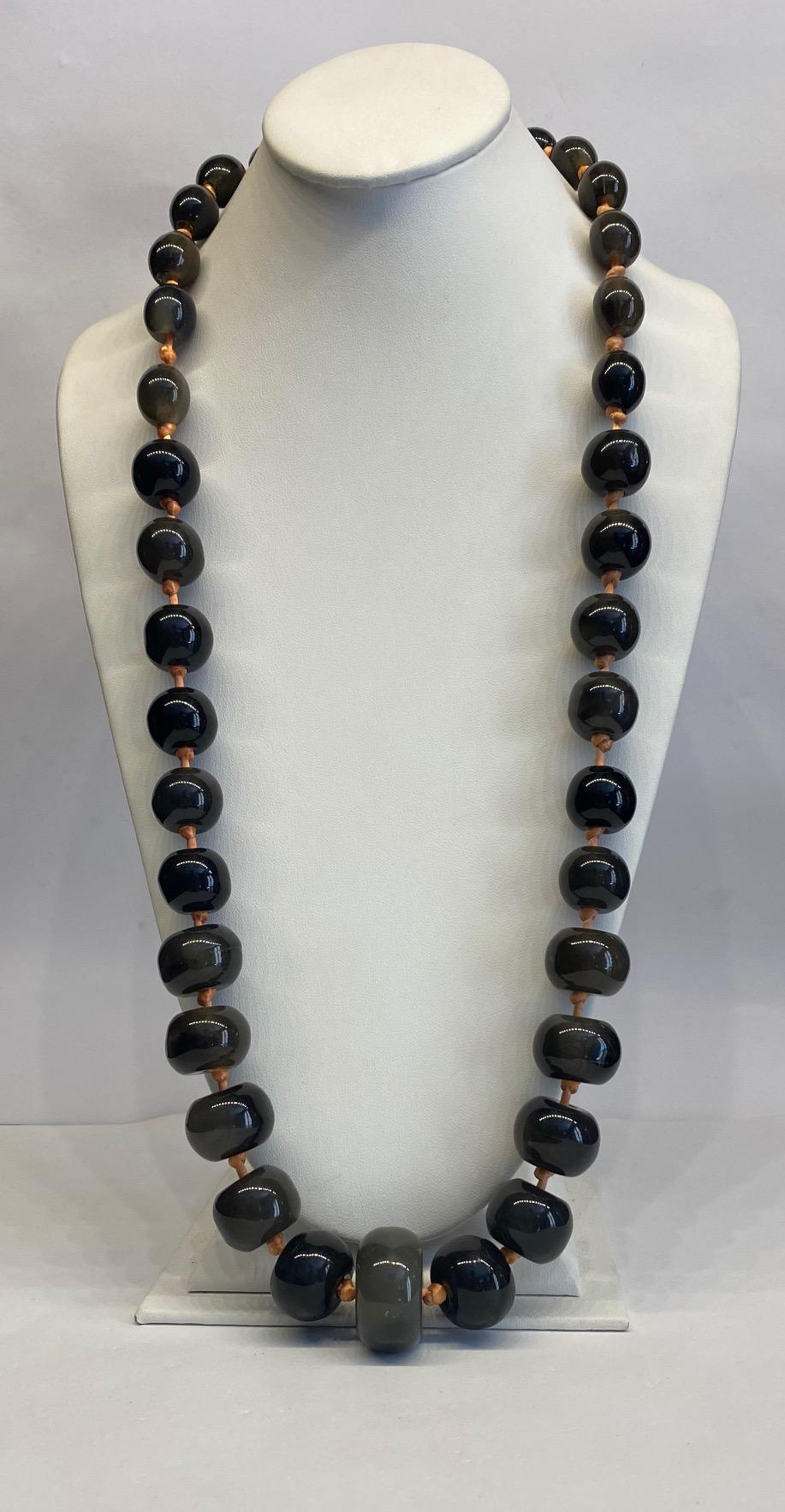 A beautifully made graduated resin bead necklace from the 1980s by Valentino Garivani. The beads are a translucent grey resin irregular in shape and color. Some are oval, some round and the largest bottom bead is a wide flattened disk shape. Each