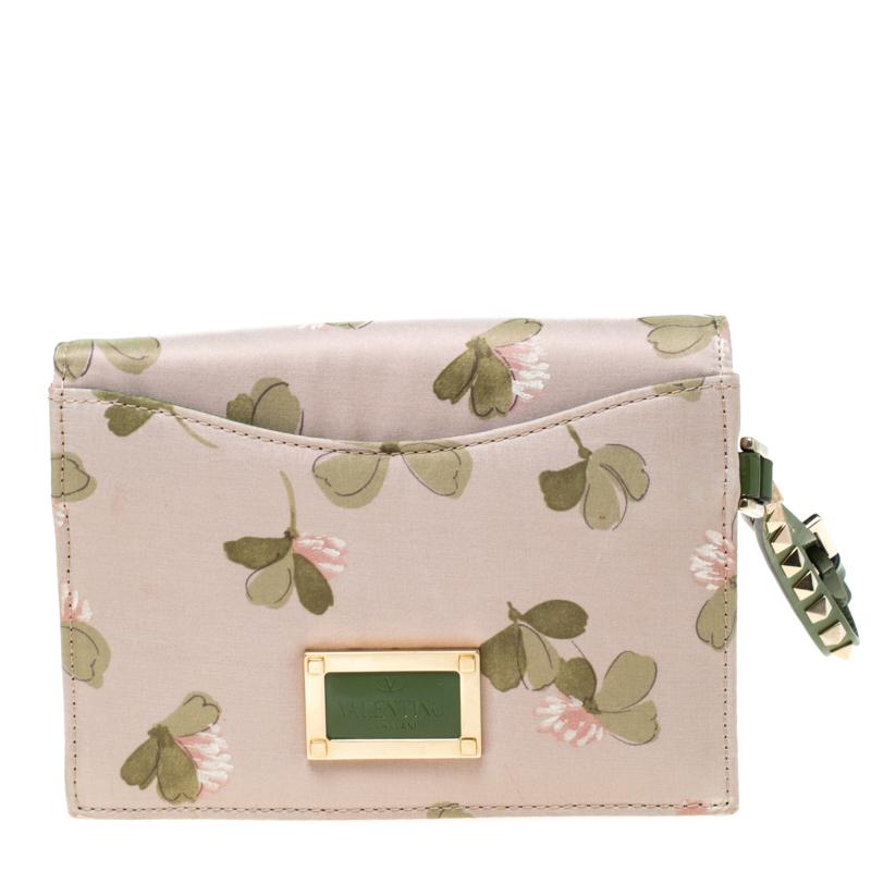 his clutch from Valentino is crafted from exquisite floral print fabric and enhanced with green trims. Flaunting a pleasing look, the clutch is styled with a bow on the front flap that features the signature Rockstuds. The well-sized interior is
