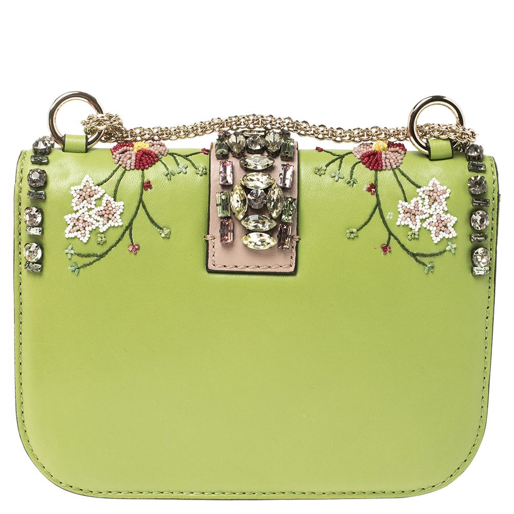 If you are looking for a bag with a blend of modern style and class, Valentino's Glam Lock bag is the answer. We have here a special version. Crafted from leather, this piece comes decorated with crystals and beads. It has a gold-tone chain and a