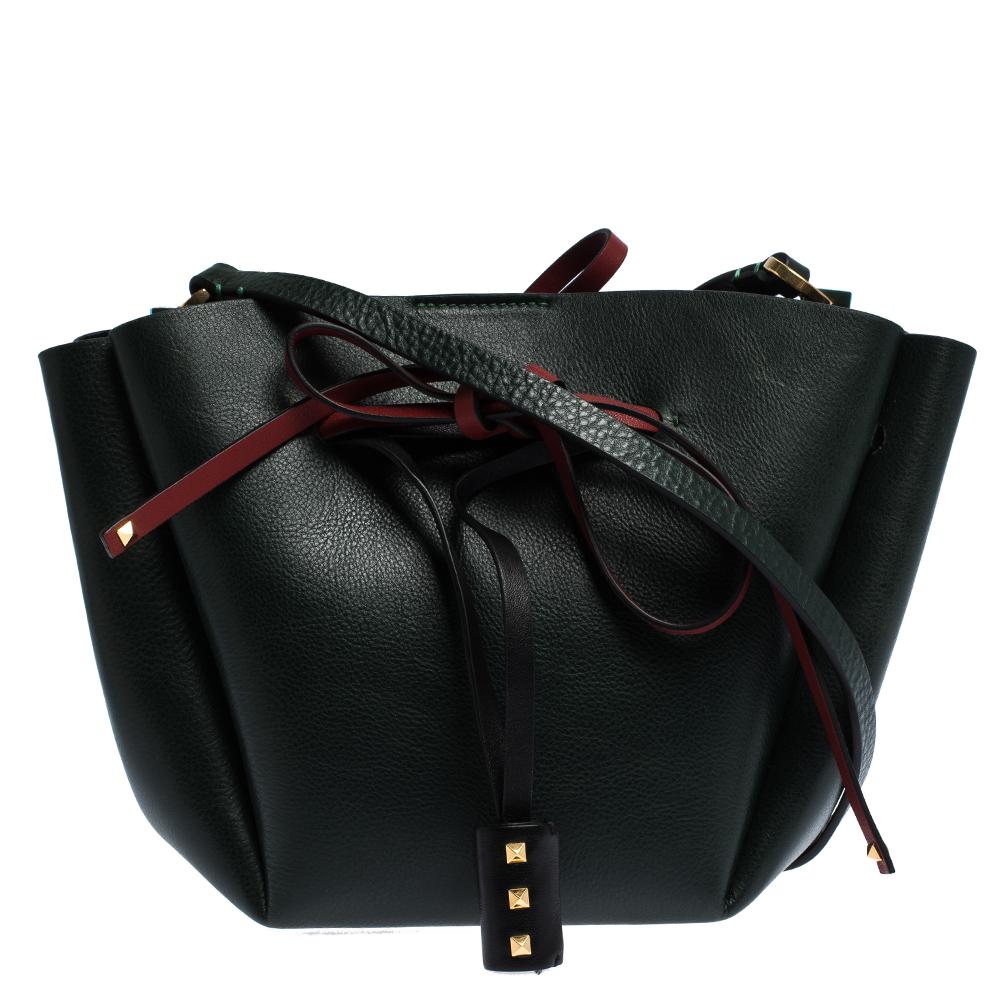 This bucket bag by Valentino is a beauty. It has been crafted from quality leather and comes in a style of leather ties and a shoulder strap. Complete with a spacious interior for your essentials, this versatile bucket bag will be the perfect day to