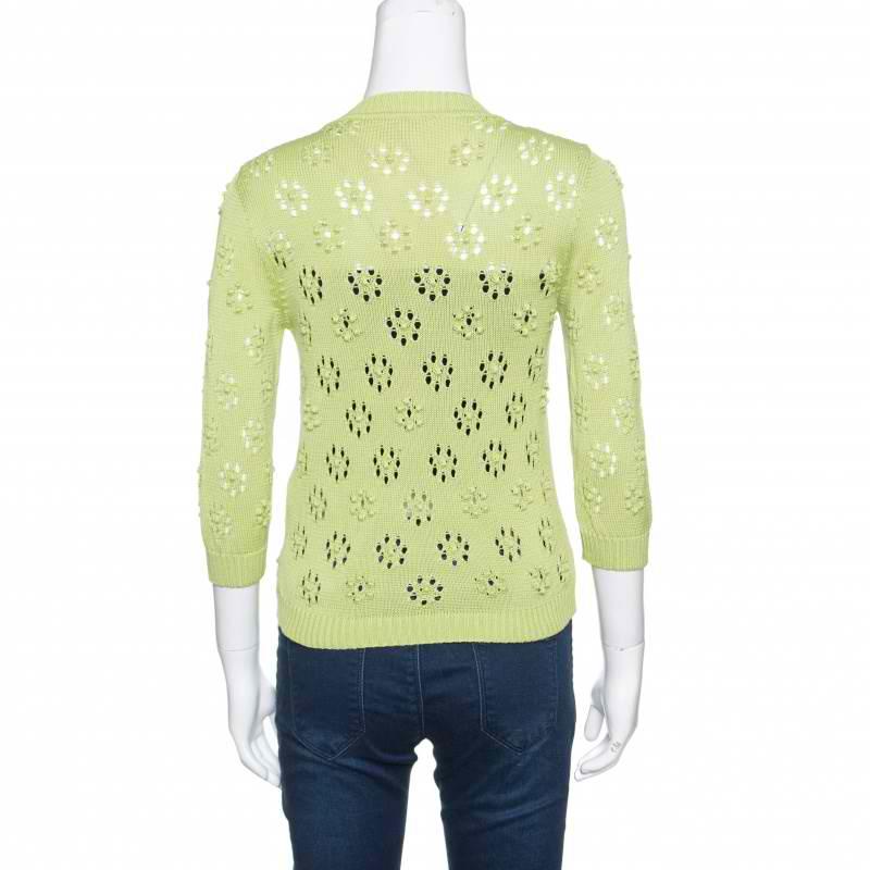 Be fashionably warm in this bobble knit cardigan by Valentino. The green coloured cardigan can be worn over jeans or skirts for a chic look. It features a front button closure and a perforated design. It can be paired up with a contrasting woolen