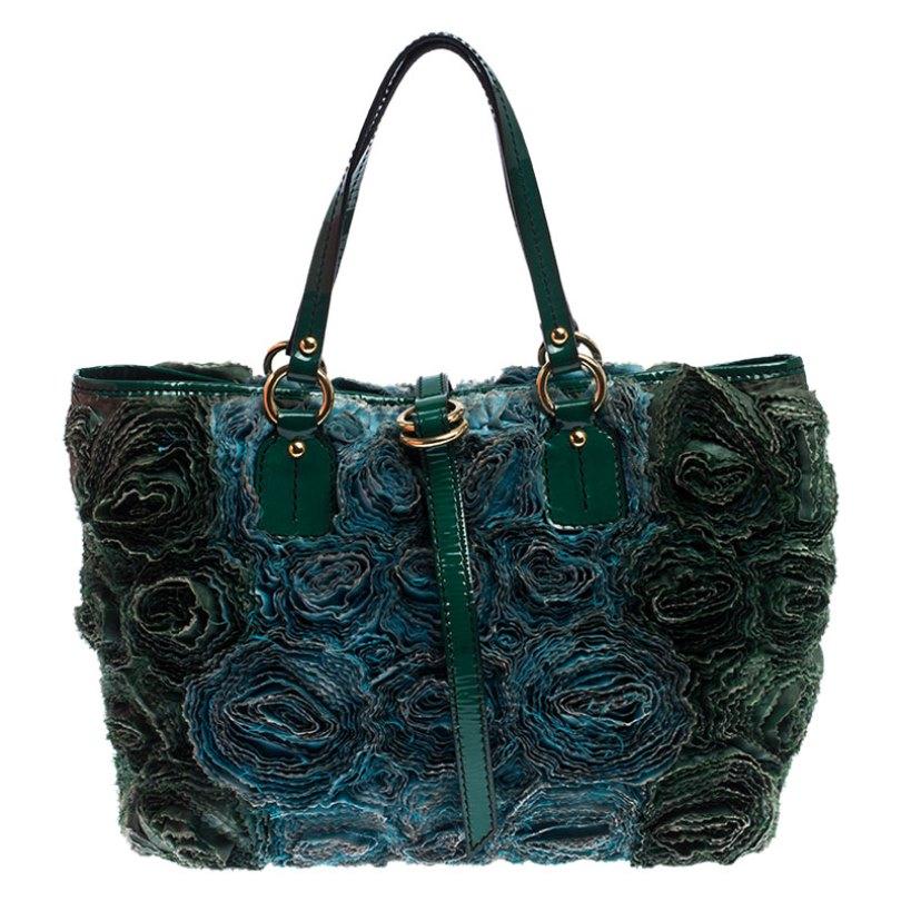 This green Valentino tote will have you turning heads in no time! This stunning bag is crafted from leather and then further adorned with intricate taffeta roses made from silk. The leather handles contrast well with the beautiful floral appliques