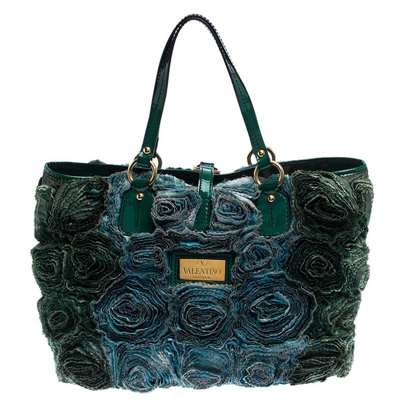 Mit dieser grünen Valentino-Tasche werden Sie im Handumdrehen die Blicke auf sich ziehen! Diese atemberaubende Tasche ist aus Leder gefertigt und mit aufwendigen Taftrosen aus Seide verziert. Die Ledergriffe kontrastieren gut mit den schönen