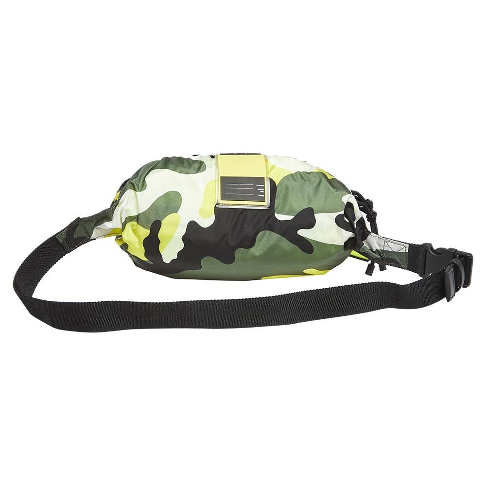 This Valentino belt bag brings a modern silhouette with a camouflage print all over in the shades of green and yellow. Crafted from nylon, the belt bag is styled with a zip pocket at the front and the brand logo at the top. The bag has a nylon