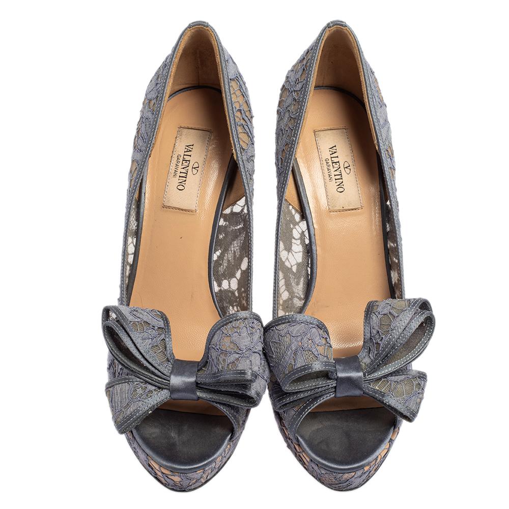Create an aura of elegance with these stunning peep-toe pumps from Valentino. These grey pumps are crafted from lace & satin. The pair flaunts couture bow detailing on the uppers, leather-lined insoles, solid platforms, and 15 cm heels. Grab these