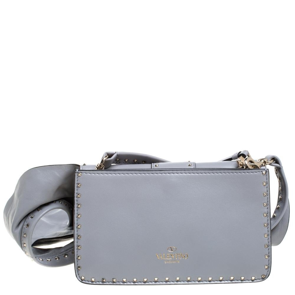 An indispensable accessory, this Valentino bag arrives in a soft grey shade. The excellent craftsmanship and a sprinkle of signature studs define the creation. The bag is accompanied by a ruffle shoulder strap that can be detached and used with