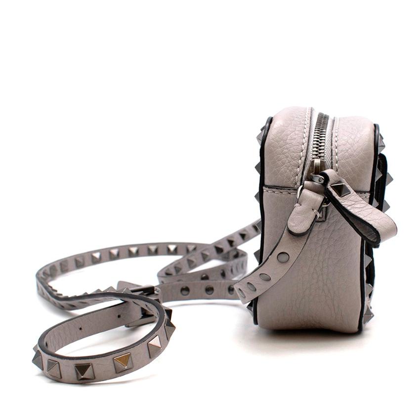 Valentino Grey Leather Rockstud Mini Shoulder Bag 

-Grainy calfskin leather
-Opal grey hue 
- Graphite studs and hardware 
-Flap pocket to the front 
-Branding to the back
- Zip closure to the top
- Adjustable studded strap 
- Suede interior with