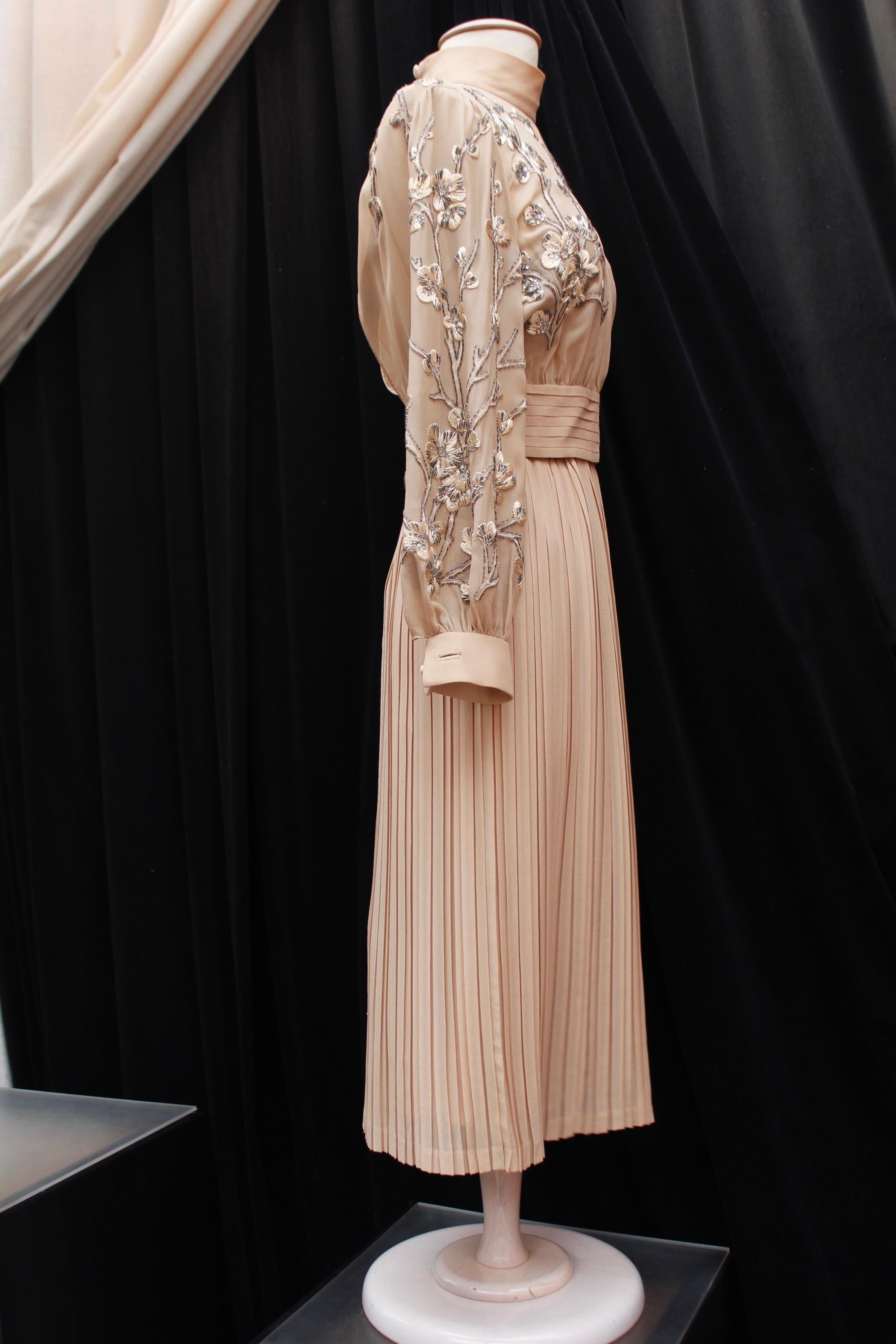 VALENTINO COUTURE (Made in Italy) Lovely nude silk chiffon evening set comprised of a dress and a top. The dress features a skater cut with pleats from the waist down and thin shoulder straps. It is lined with silk chiffon and closes with a back