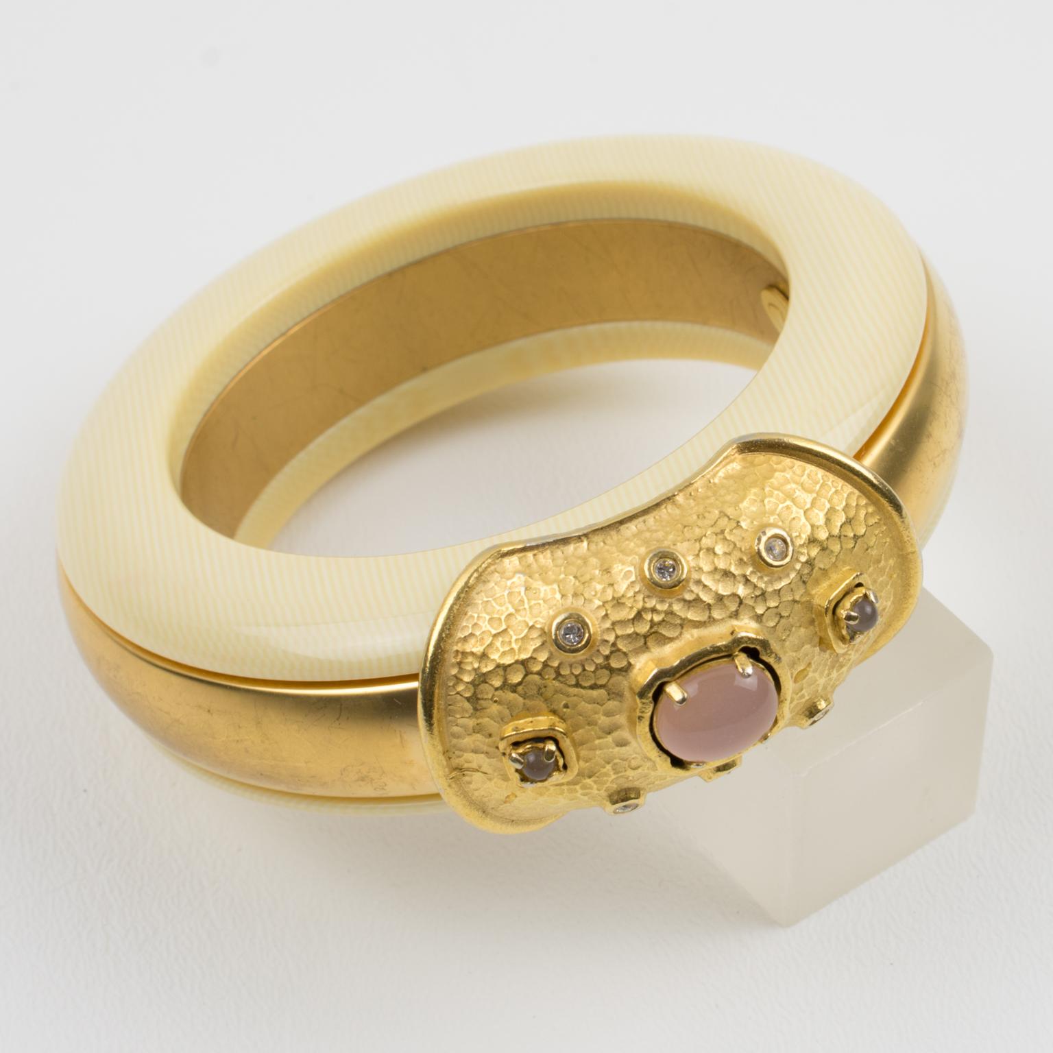 Cet étonnant bracelet bangle Valentino Garavani Haute Couture présente une forme bombée massive avec un design laminé construit avec du métal doré dans un aspect satiné contrasté avec de la résine blanc cassé avec une texture faux-ivoire. Le