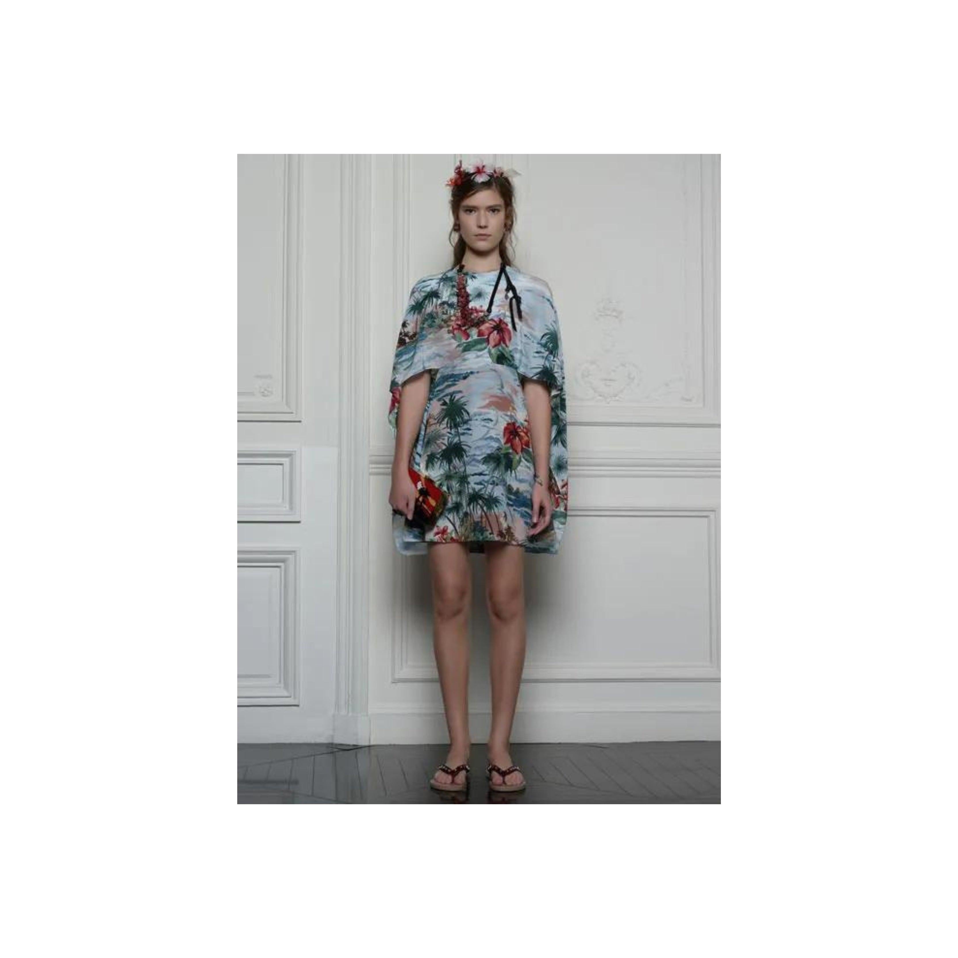 Introducing the Valentino Hawaiian Couture Cape Dress from the exclusive 2016 capsule collection. This blue printed dress features a cutout accent at the back and a boat neck for a stunning and bold look. The cape which falls over the shoulder has a