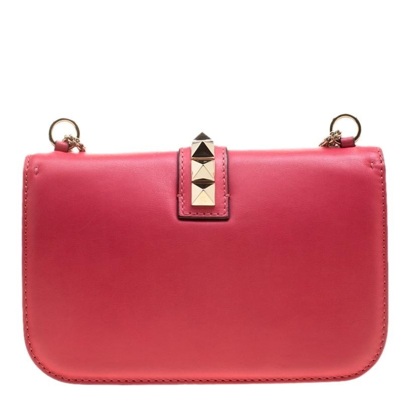 If you are looking for a bag with a blend of modern style and class, this Valentino shoulder bag is the answer. The striking hot pink bag comes with the iconic Rockstud trim. Made in Italy, the bag is crafted from leather and has a fabric lined