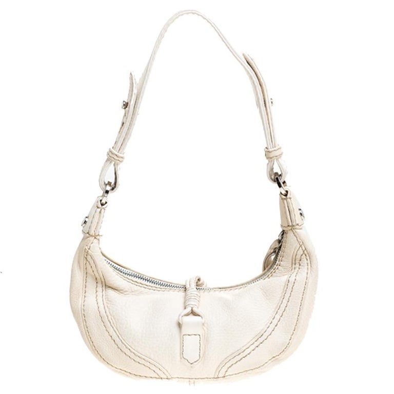 This mini hobo from Valentino is an absolute stunner. The exterior is crafted from lovely ivory leather and features a satin-lined interior that is sized to house your necessities. It has a zip closure, the brand's ornate logo appears on the dangler