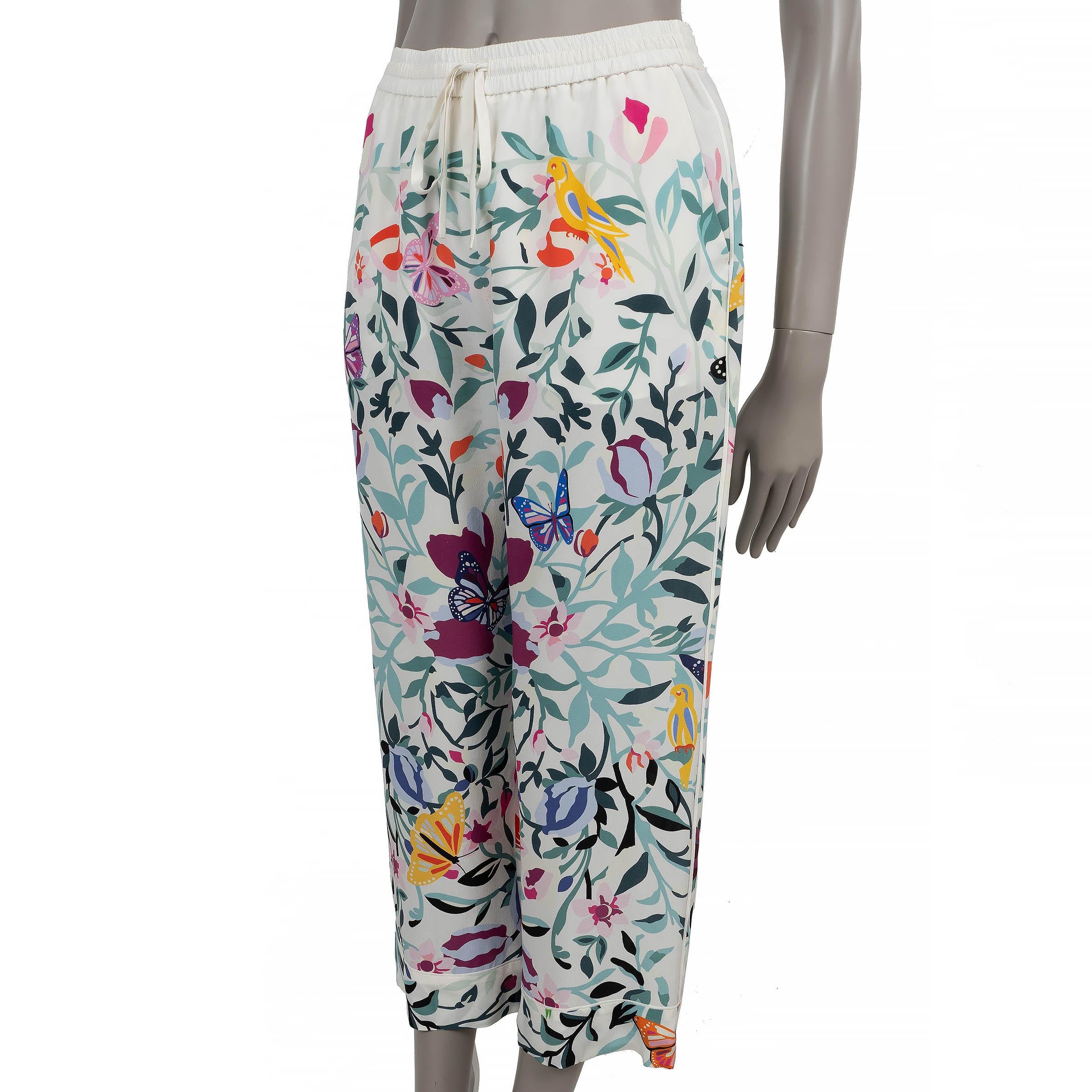 These 100% authentic Valentino pajama pants are crafted in white crepe silk with a colorful floral and butterfly print (please note the content and size tag are missing). They feature a relaxed silhouette with cropped straight legs, side slit
