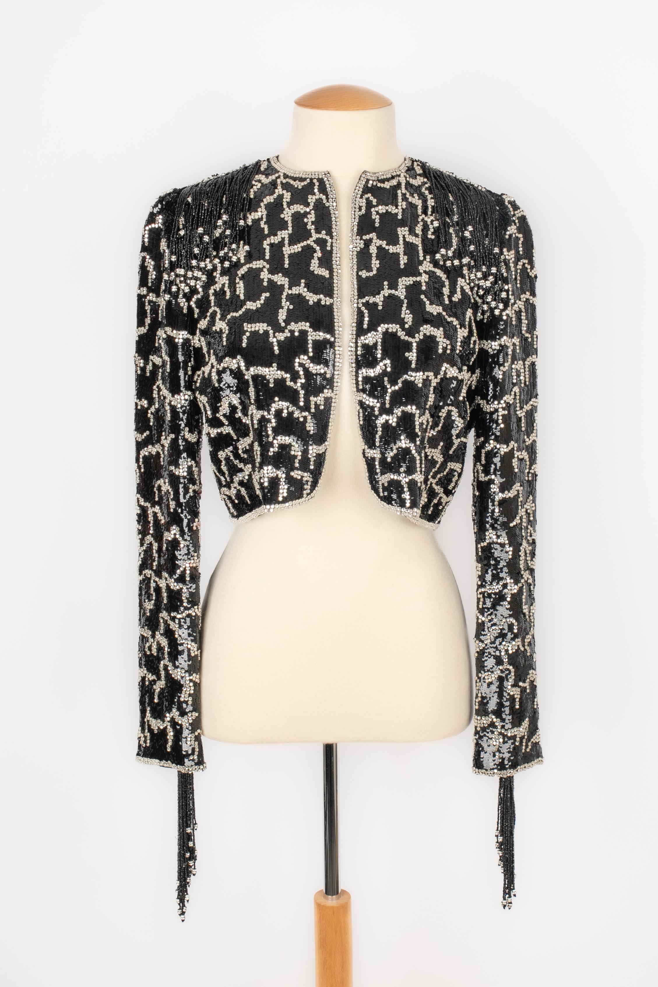 VALENTINO - Short jacket entirely embroidered with black sequins and rhinestones. Shoulders and sleeve bottoms ornamented with black pearl and sequin fringes. No size indicated, it fits a 34FR/36FR. A Collection from the 1998's.

Condition:
Very