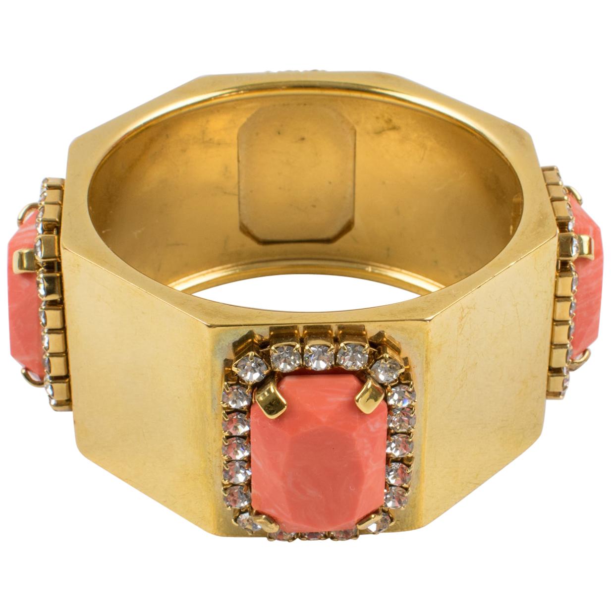 This stunning Valentino Garavani Haute Couture bracelet features a chunky faceted heavy gilded metal bangle shape ornate with tiny crystal rhinestones and large faux-coral resin cabochons (four designs all around). Valentino's hallmark is engraved