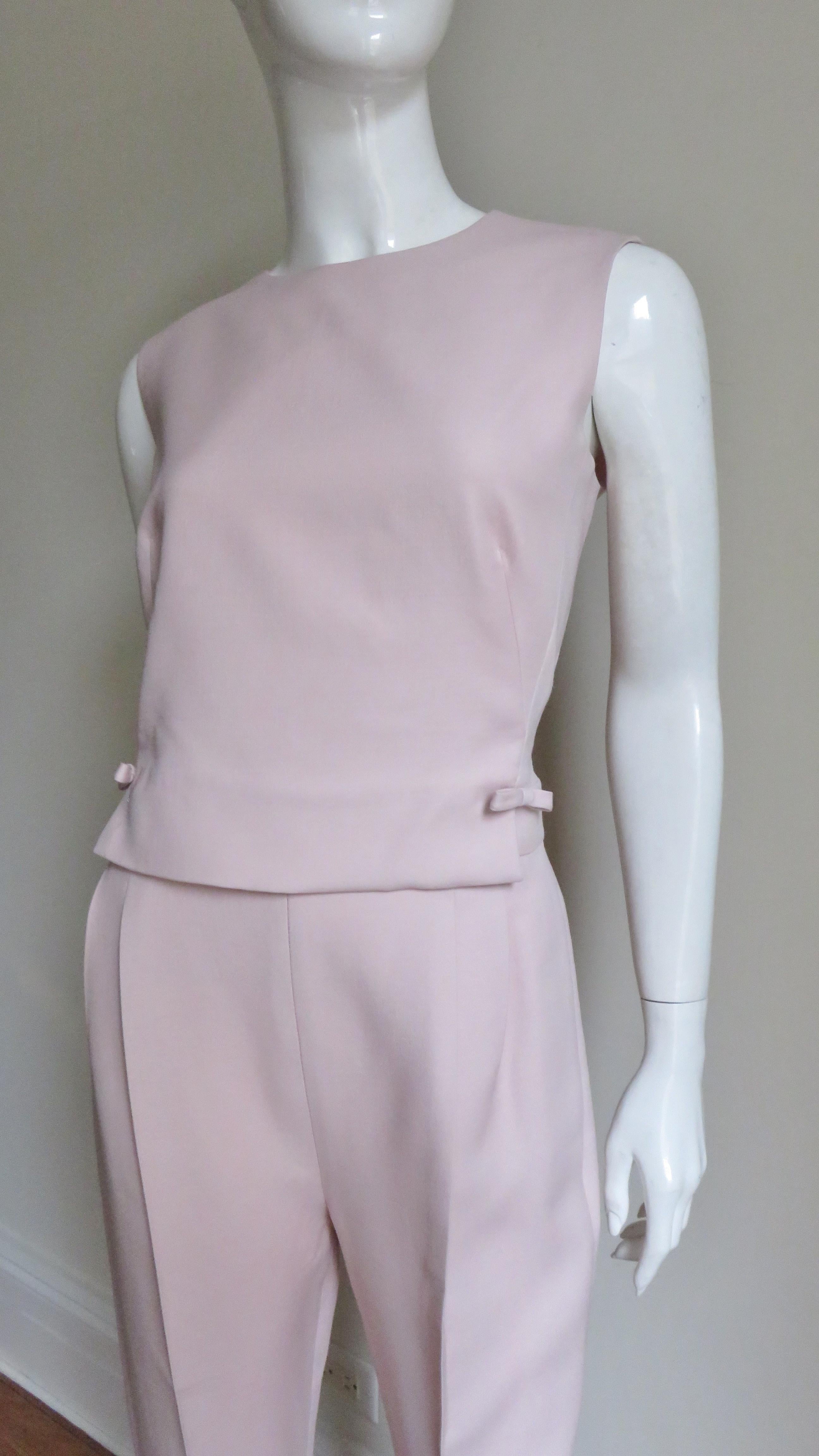 A gorgeous blush pink silk blend jumpsuit from Valentino.  It is sleeveless with a crew neckline and a triangular cut out from the upper back to the back waist. The pant legs are tapered with zippers at the ankles and pockets in the hip side seams. 