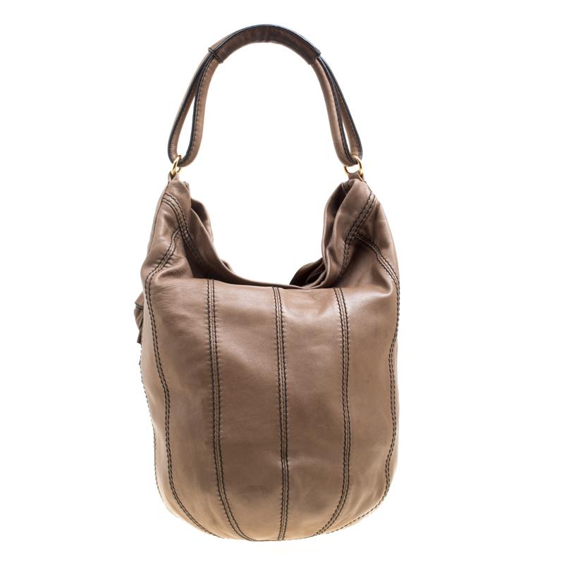 This Valentino hobo has a bucket shape and it comes in khaki brown. The bag is created from leather and detailed with ruffles and rose appliques, a single handle and a spacious fabric interior for your essentials. It is gorgeous and ideal for daily