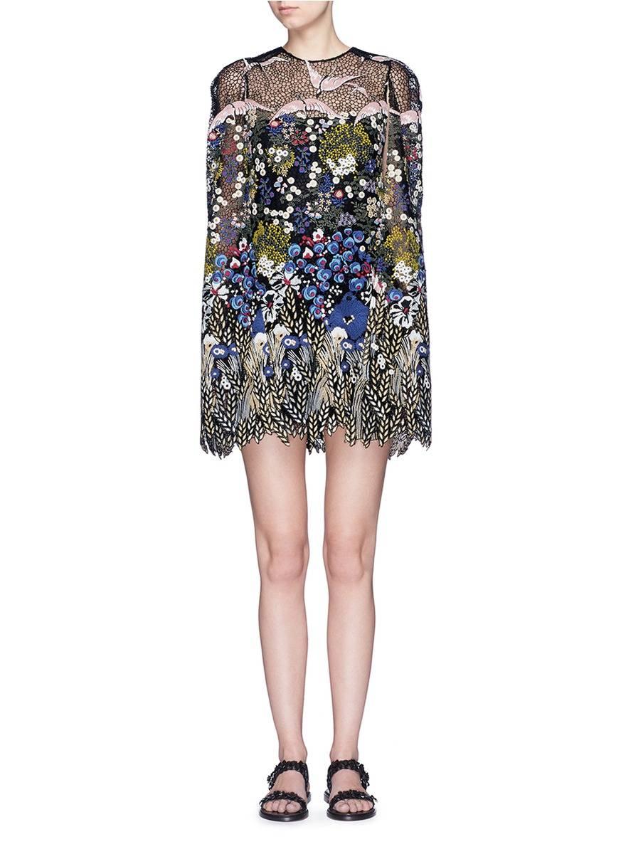 VALENTINO cocktail dress comes in black silk blend lace and mesh and features a round neckline, shift silhouette dress, attached cape overlay, and beautiful floral and bird landscape embroidery throughout. Made in Italy.  Retail: $10,615.00
