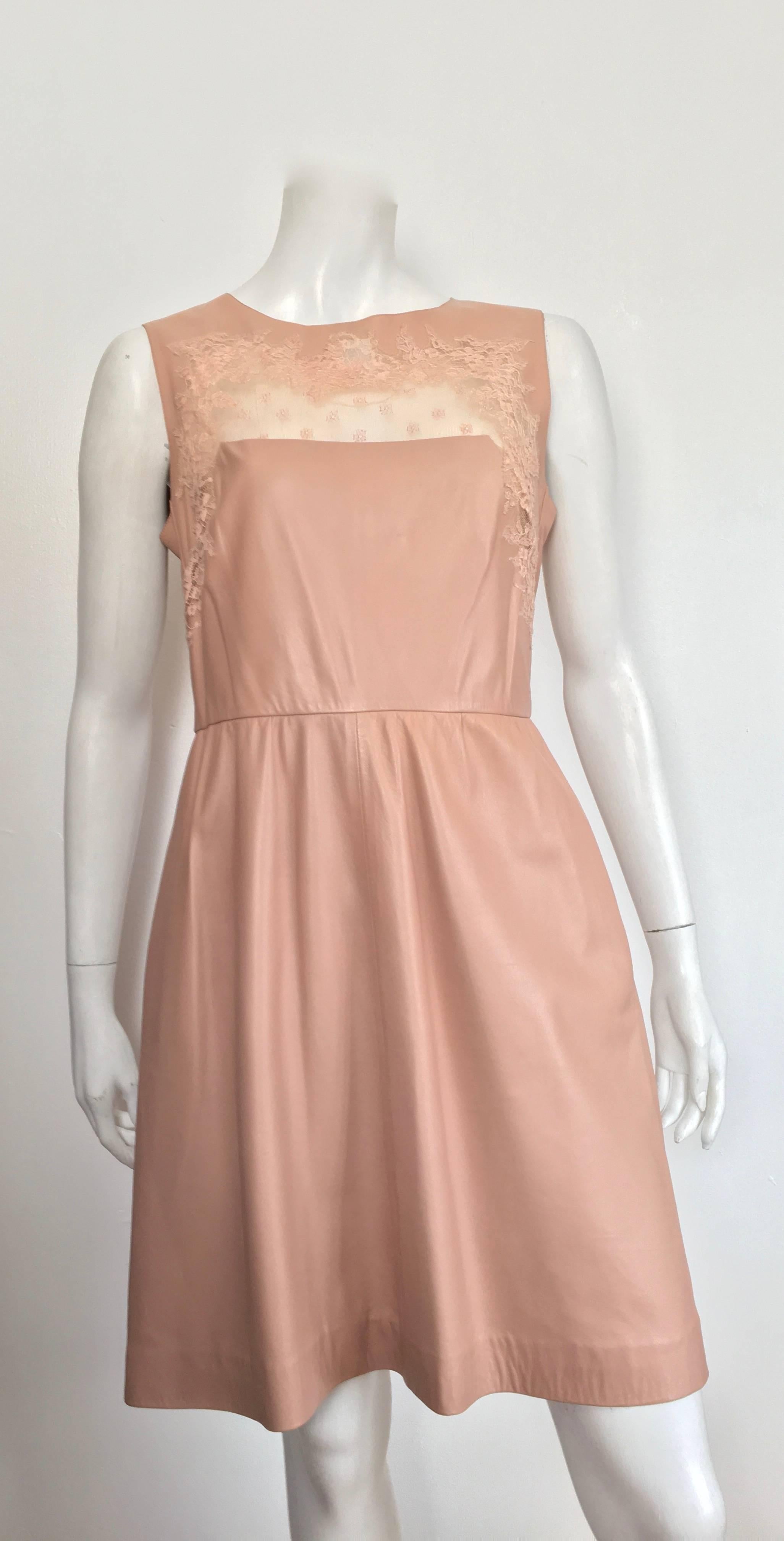 Valentino earth tone color leather with lace around décolletage evening cocktail sleeveless dress with pockets is a size 8.  Every stitch of this dress is meticulously thought out, it is impeccable. Dress is lined. Whether you are attending the