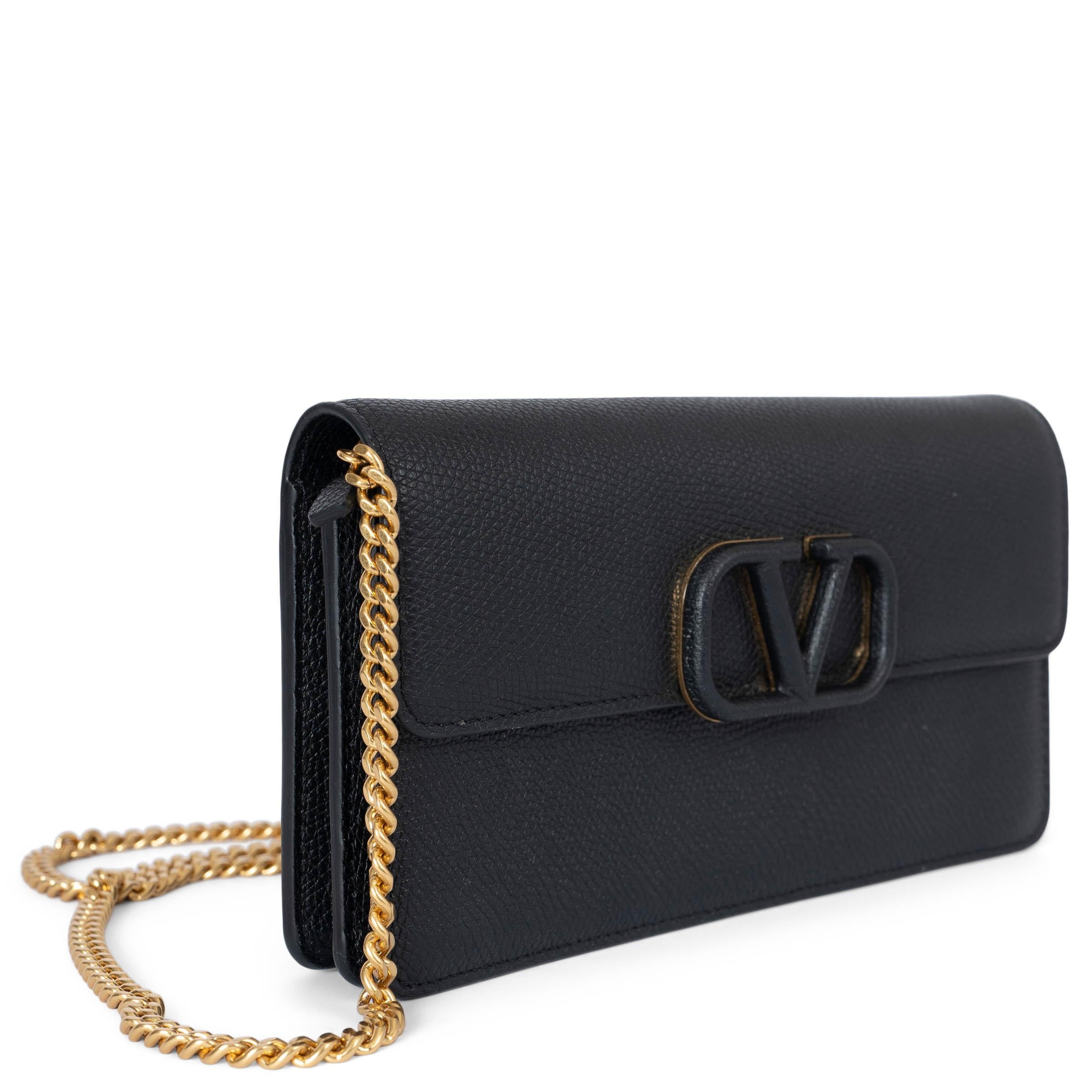 This 100% authentic Valentino Garavani wallet showcases the iconic VLogo, embodying the Maison's legacy of elegance. Crafted from black grainy leather, the wallet features a gold-tone chain shoulder strap and a magnetic fastening. Inside, you'll