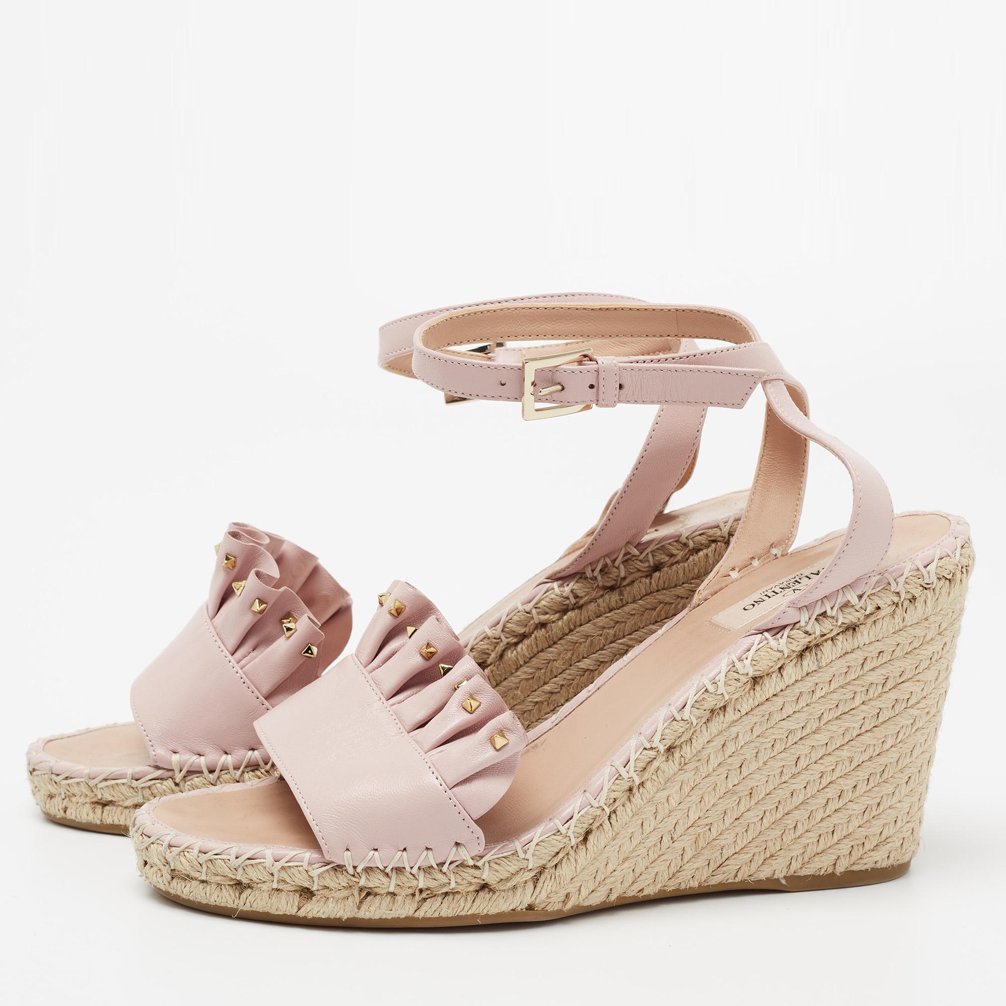 Embrace the season with these Valentino sandals on your feet. Made from light pink leather, they have open toes, ankle straps with buckle closure, and espadrille wedge heels.

