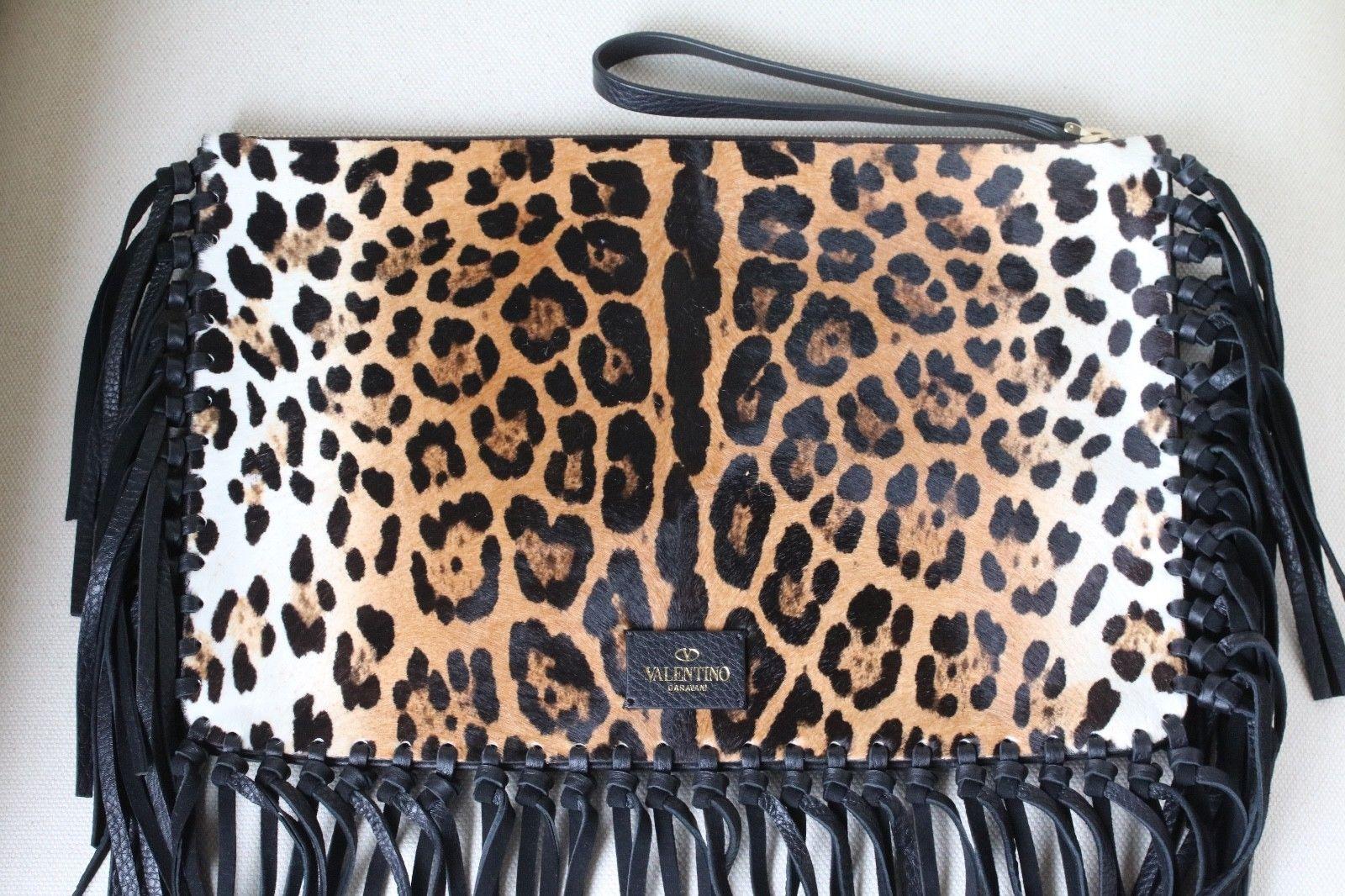 Fun fringe lends eye-catching appeal to this luxe calfskin clutch from Valentino. Animal print calfskin, black fringed trim, top zip with pull, inside back wall zip pocket. Calfskin/Leather.

Dimensions: Approx. 14 x 9 x 0.5 inches

Condition: New