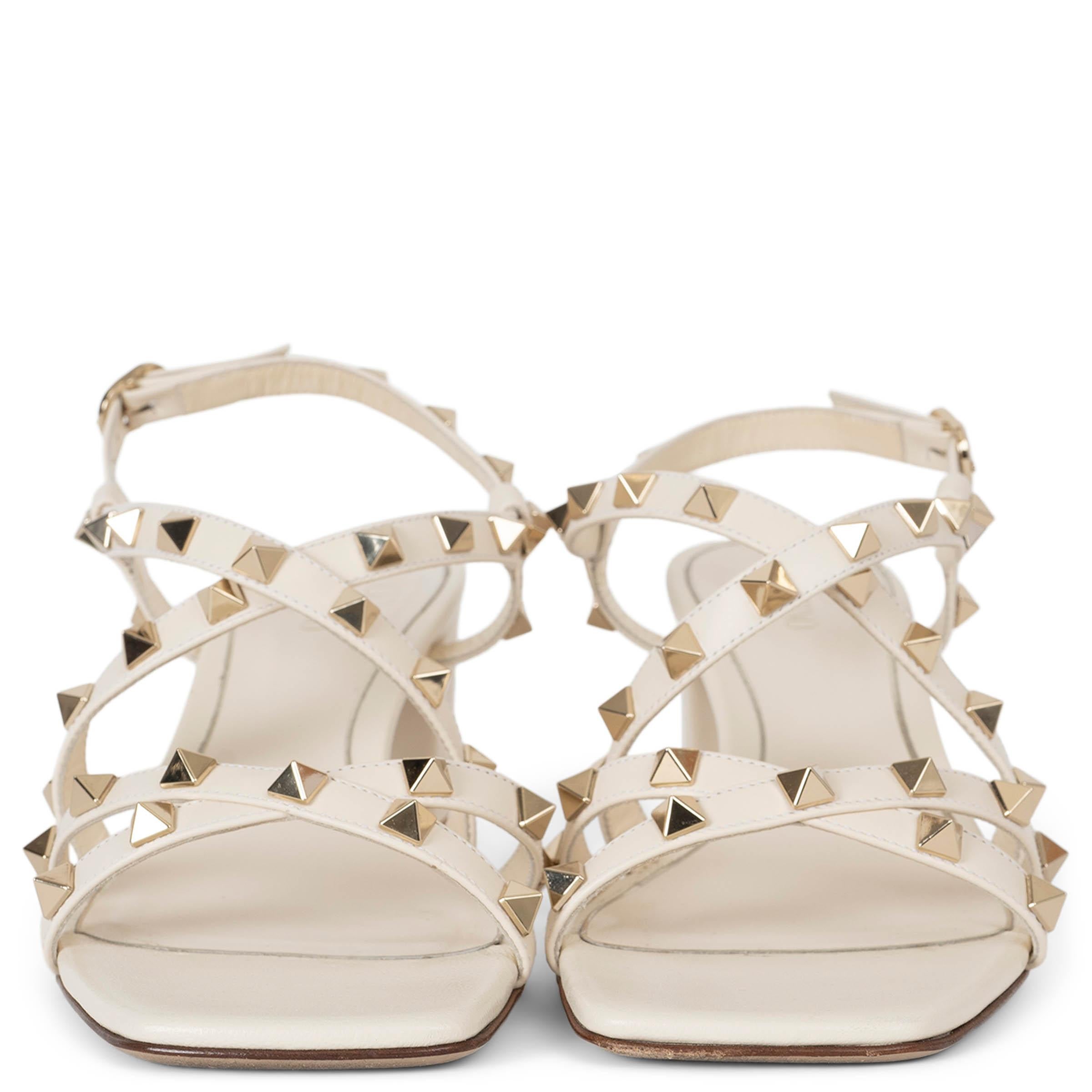 These 100% authentic Valentino Garavani Rockstud Sandals in ivory calfskin exude elegance and sophistication. Crafted from premium calfskin leather, they feature Valentino's signature platinum-finish studs, adding a touch of edgy glamour. The design