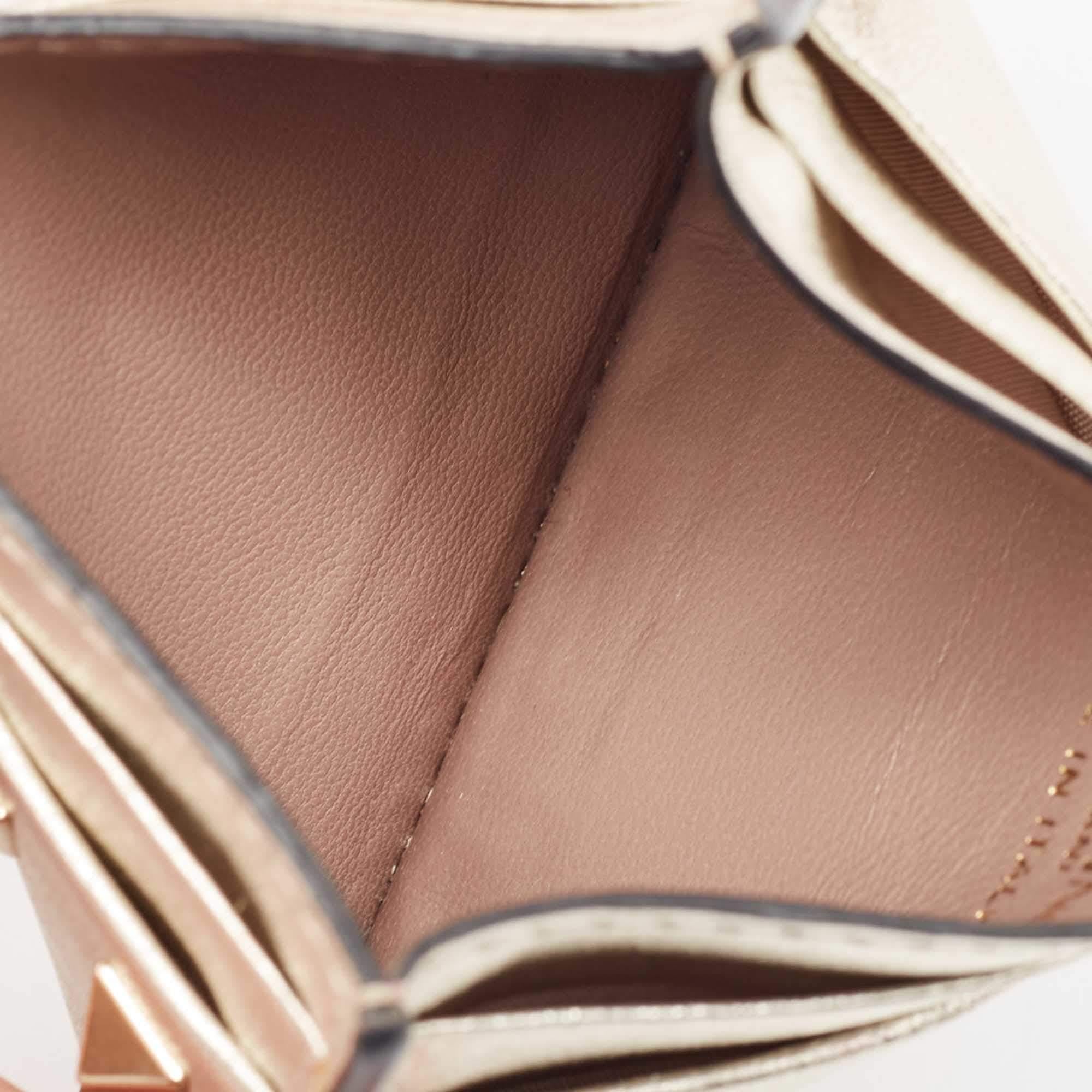 Valentinos Kartenetui aus hochwertigem Leder mit charakteristischen Rockstud-Details auf der Außenseite und Kartenfächern auf beiden Seiten. Das zierliche Modell passt problemlos in Ihre Alltagstasche.