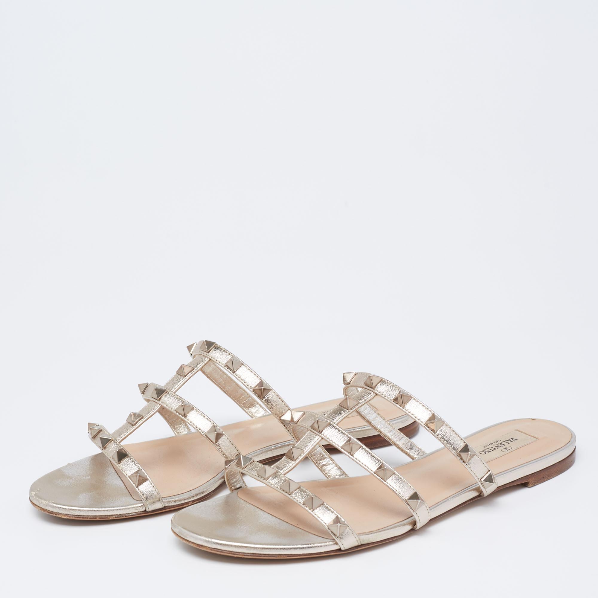 These Valentino slides feature a gorgeous design of light gold leather straps detailed with the signature Rockstuds. Easy to slide on and off, this pair complements dresses and pants alike.