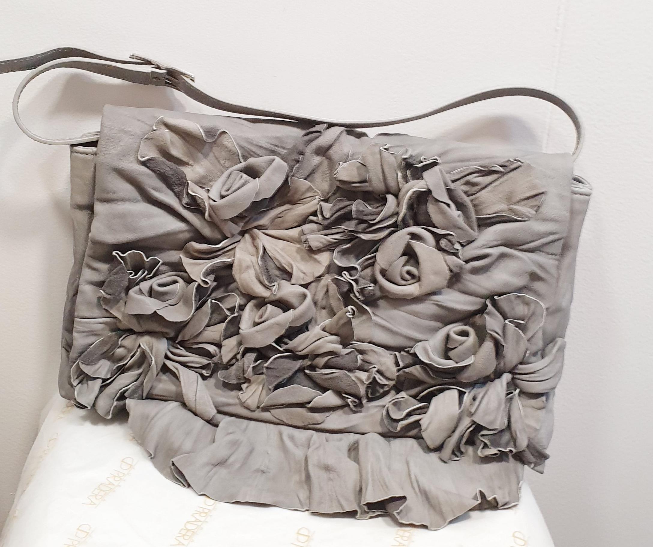 100% authentic Valentino shoulder bag with attached flowers in light gray wrinkled leather. Opens with a magnetic snap button under the flap. Lined in pearl gray satin with one zipper pocket against the back.. Comes with dust bag.

Width: 34cm