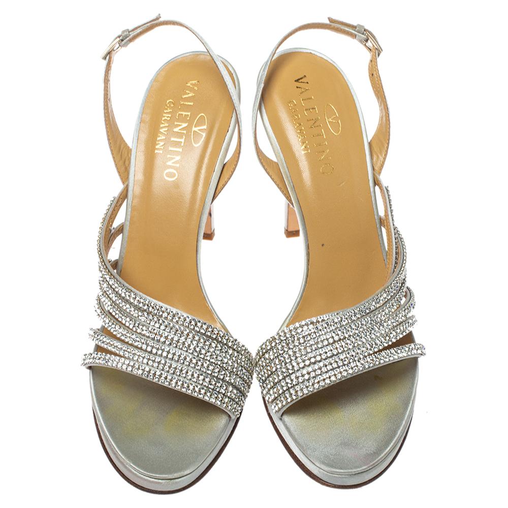 Create the most eye-catching party looks wearing these super stylish Valentino sandals. Constructed from light grey satin, these open-toe sandals along with their slingbacks and 11.5 cm heels, feature exquisite crystal-embellished vamp straps.